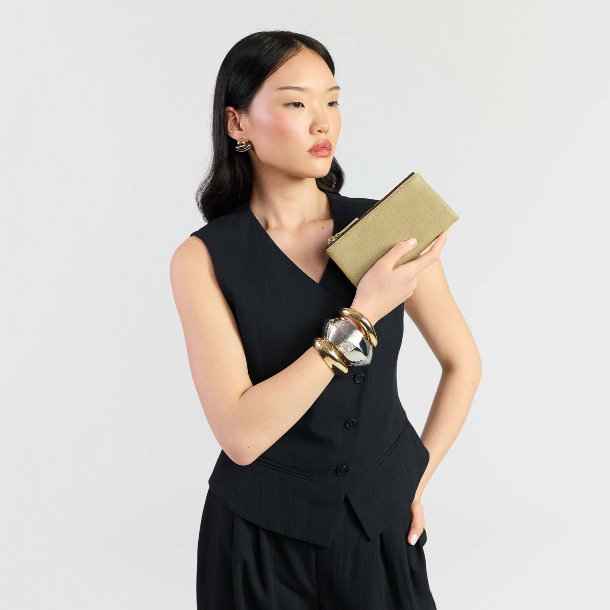 Saben Sam Wallet - Willow held by a model in a stylish outfit, showcasing elegance and functionality.