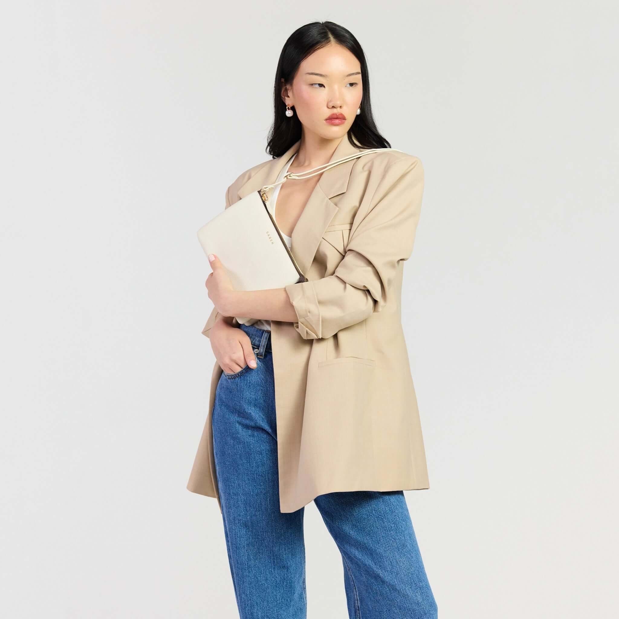 Saben Tilly's Big Sis Crossbody Bag - Quartz held by a model in a stylish beige blazer and jeans.