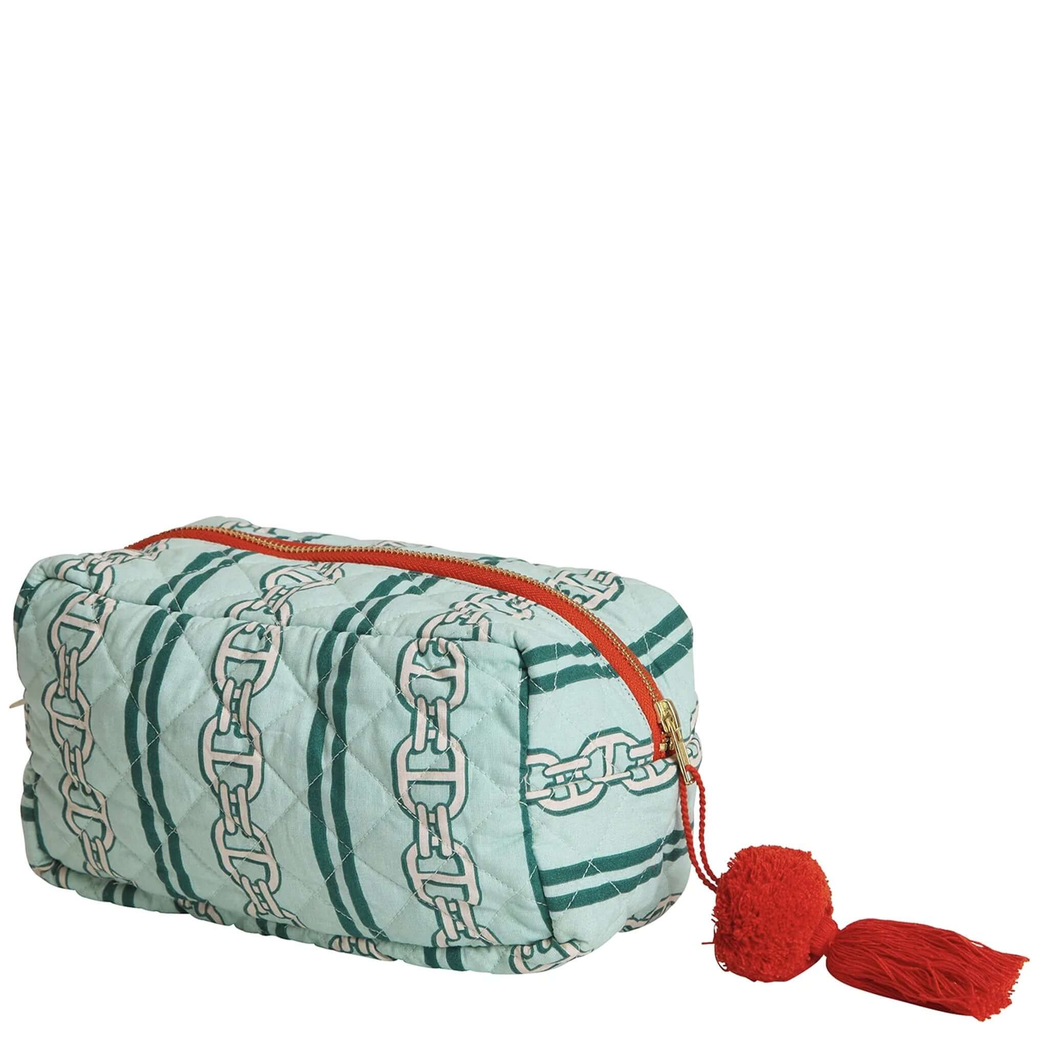 A green and multicolored striped beauty bag with a quilted texture, orange zipper, and a red tassel.