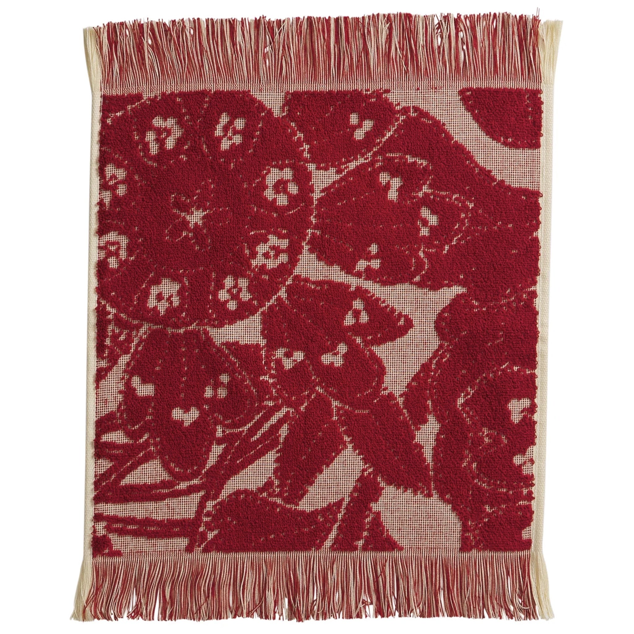 Red floral patterned face washer with beige fringe on a white background