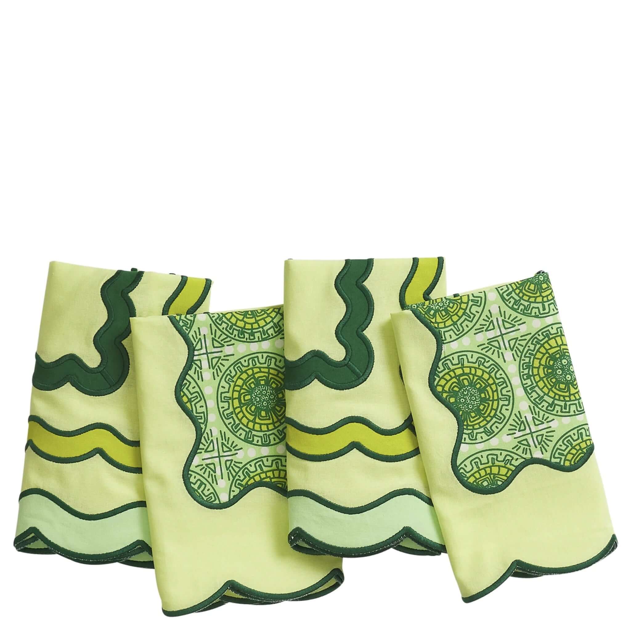 Four green and yellow patterned cloth nakpins on a white background