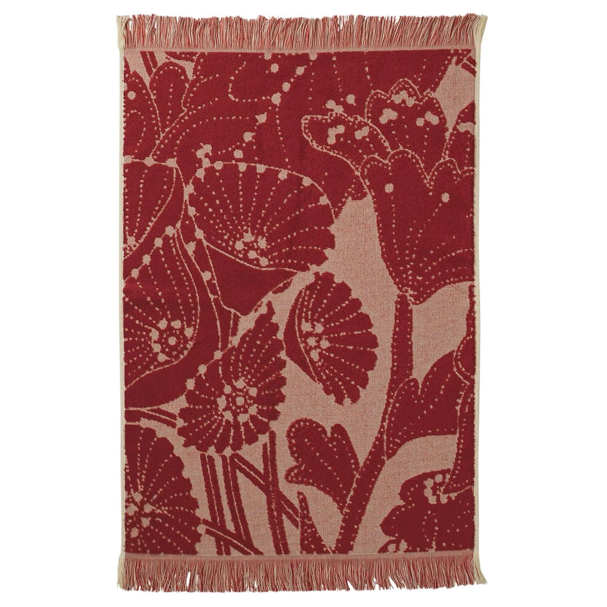 Floral patterned hand towel with fringes on a white background