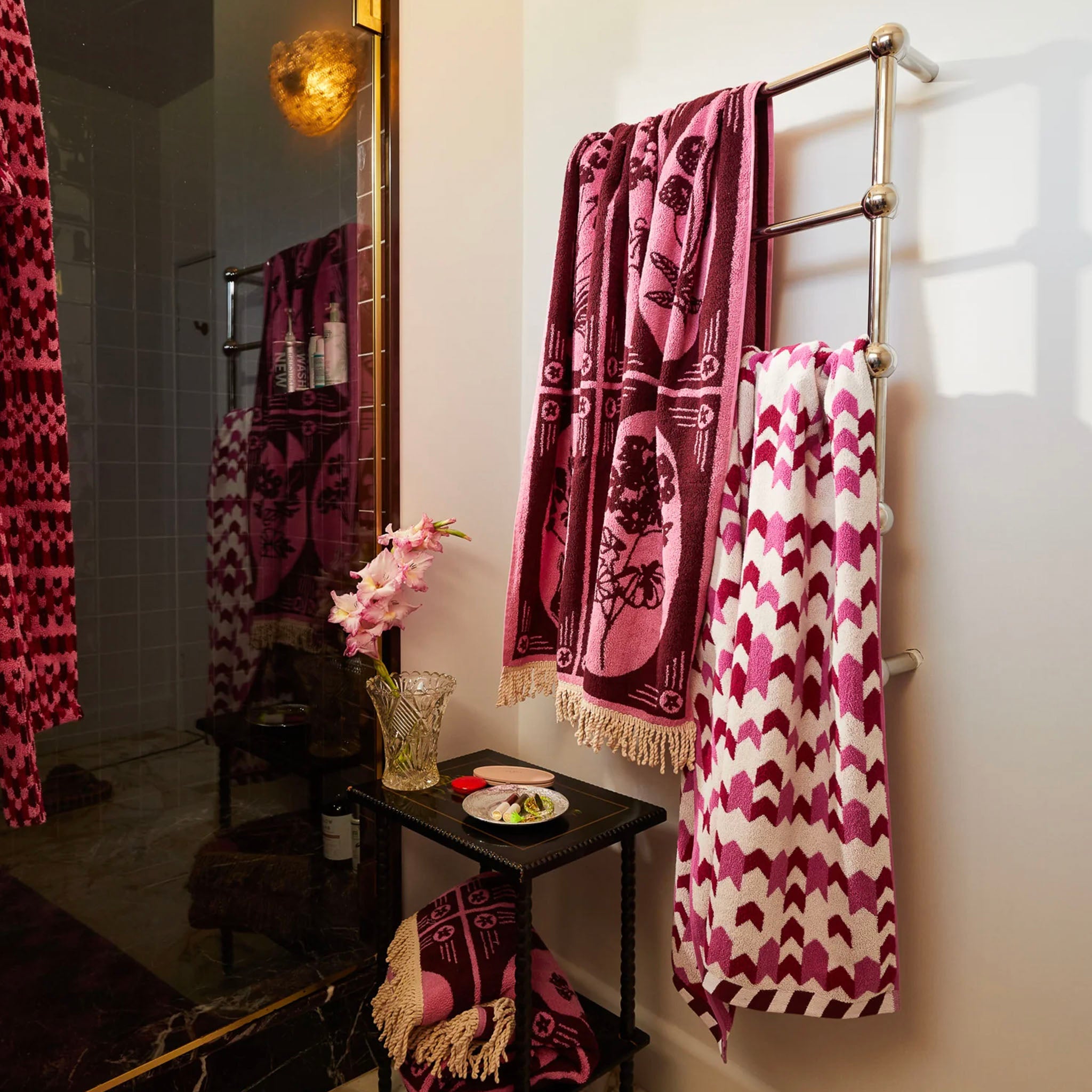 A fuchsia-colored bath sheet with a geometric pattern, made from organic cotton terry toweling, with bound edges.