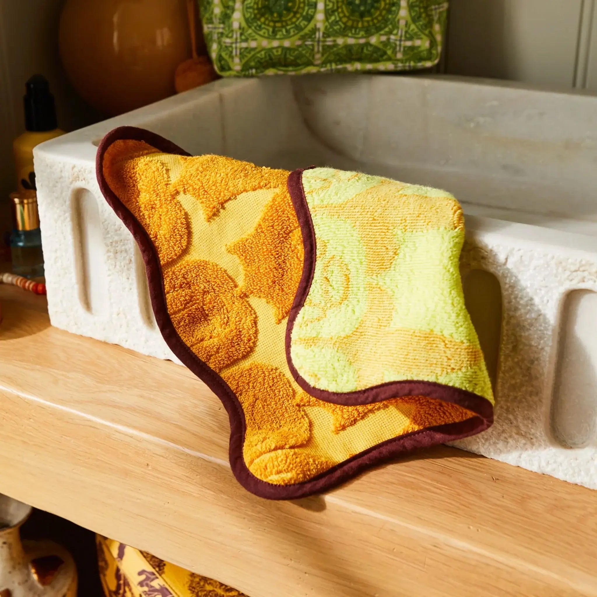 Yellow and brown textured face cloth on a wooden surface with a blurred background