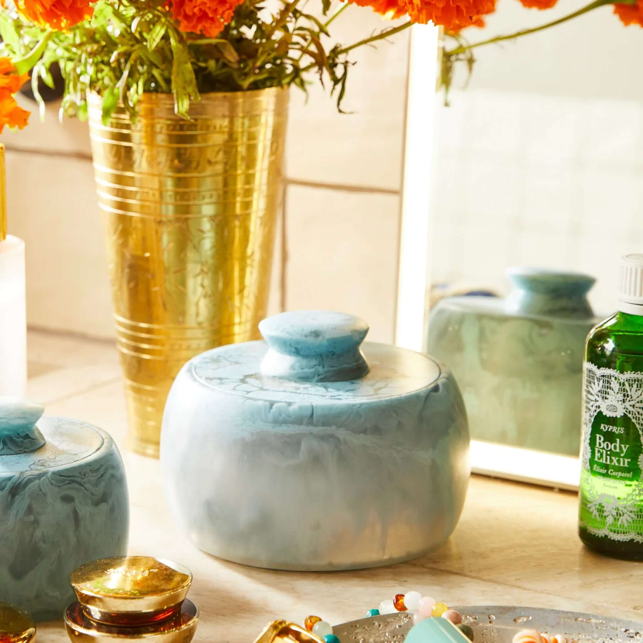 A round Sage x Clare Resin Halleck Canister with a swirling smoke-like pattern in muted colors.