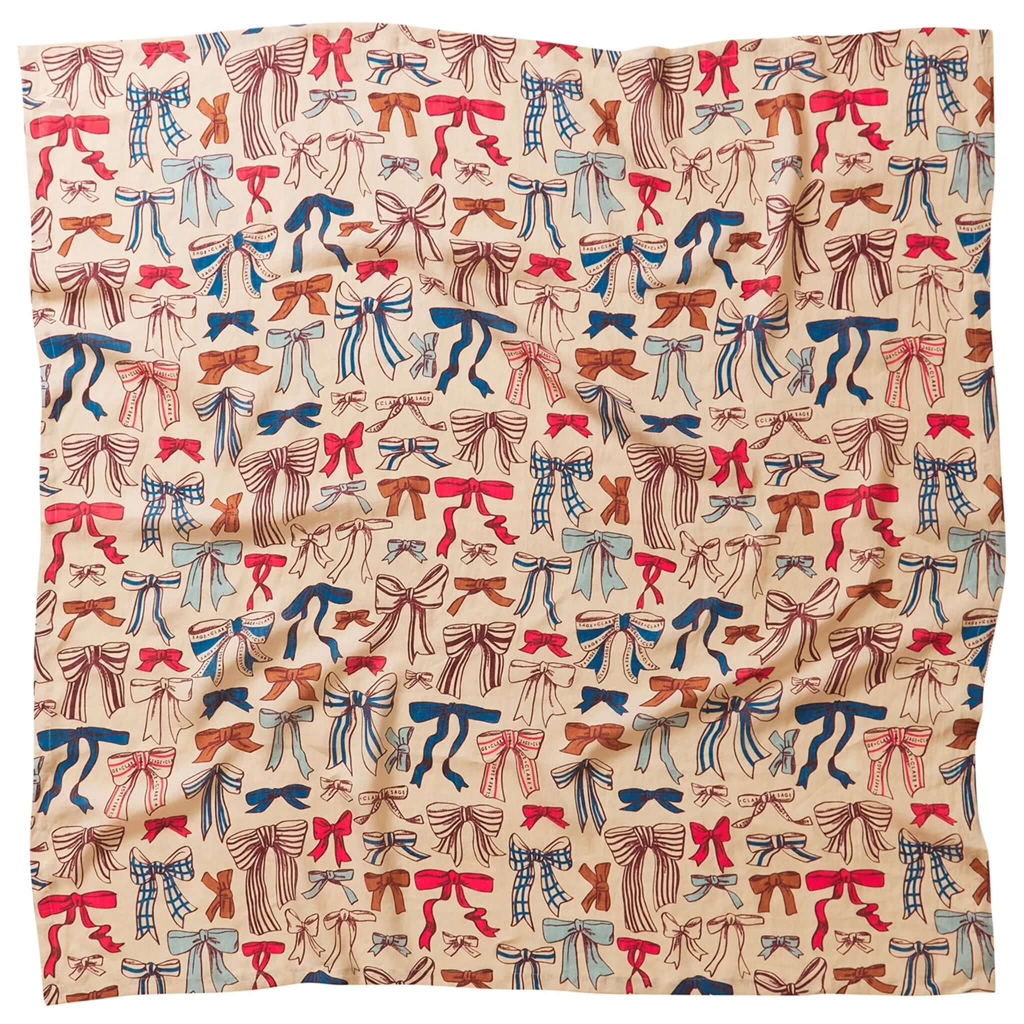 A linen tablecloth with a pattern of colorful bows in red, blue, and brown colors on a beige background.