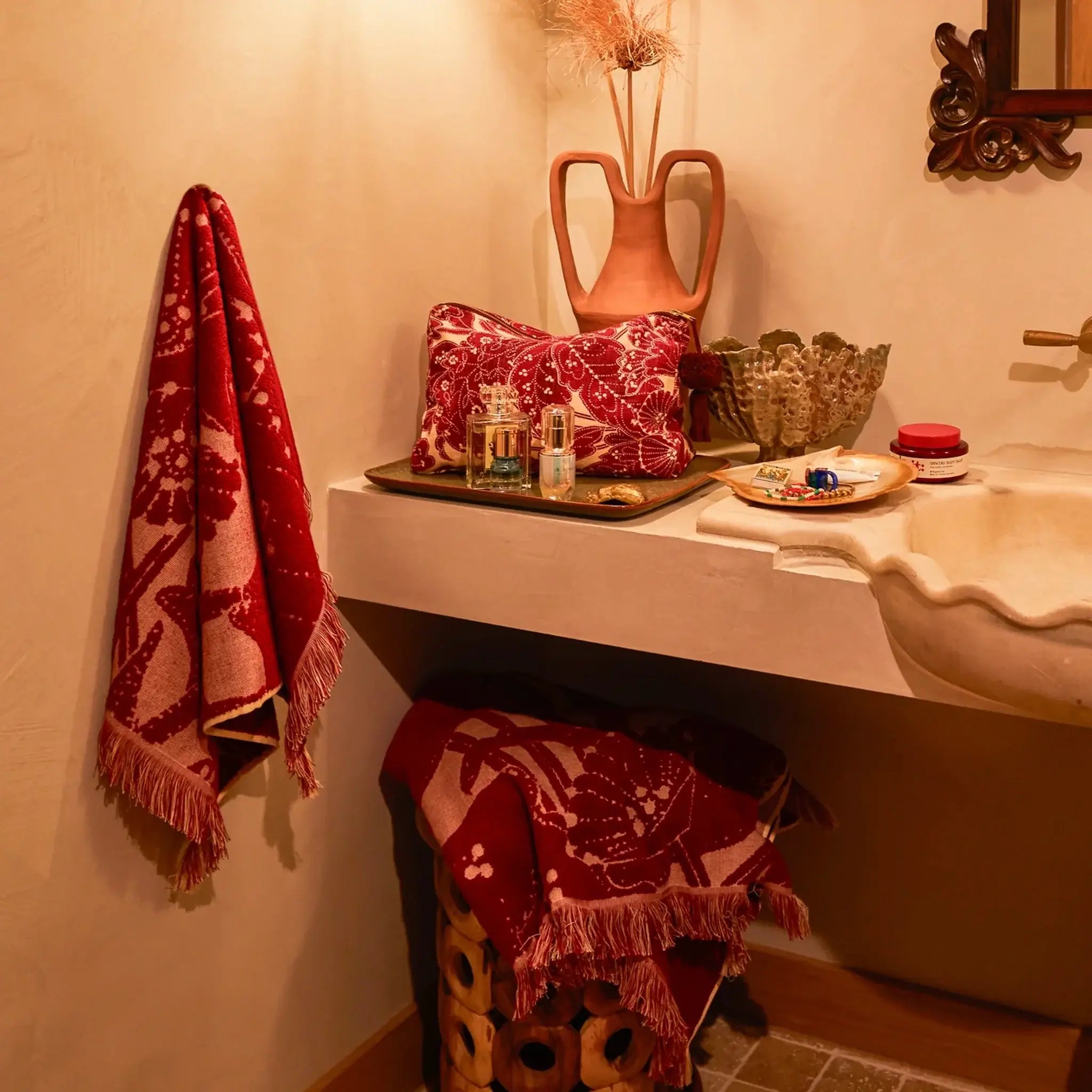Bathroom with a sink, decorative towels, and a vase.