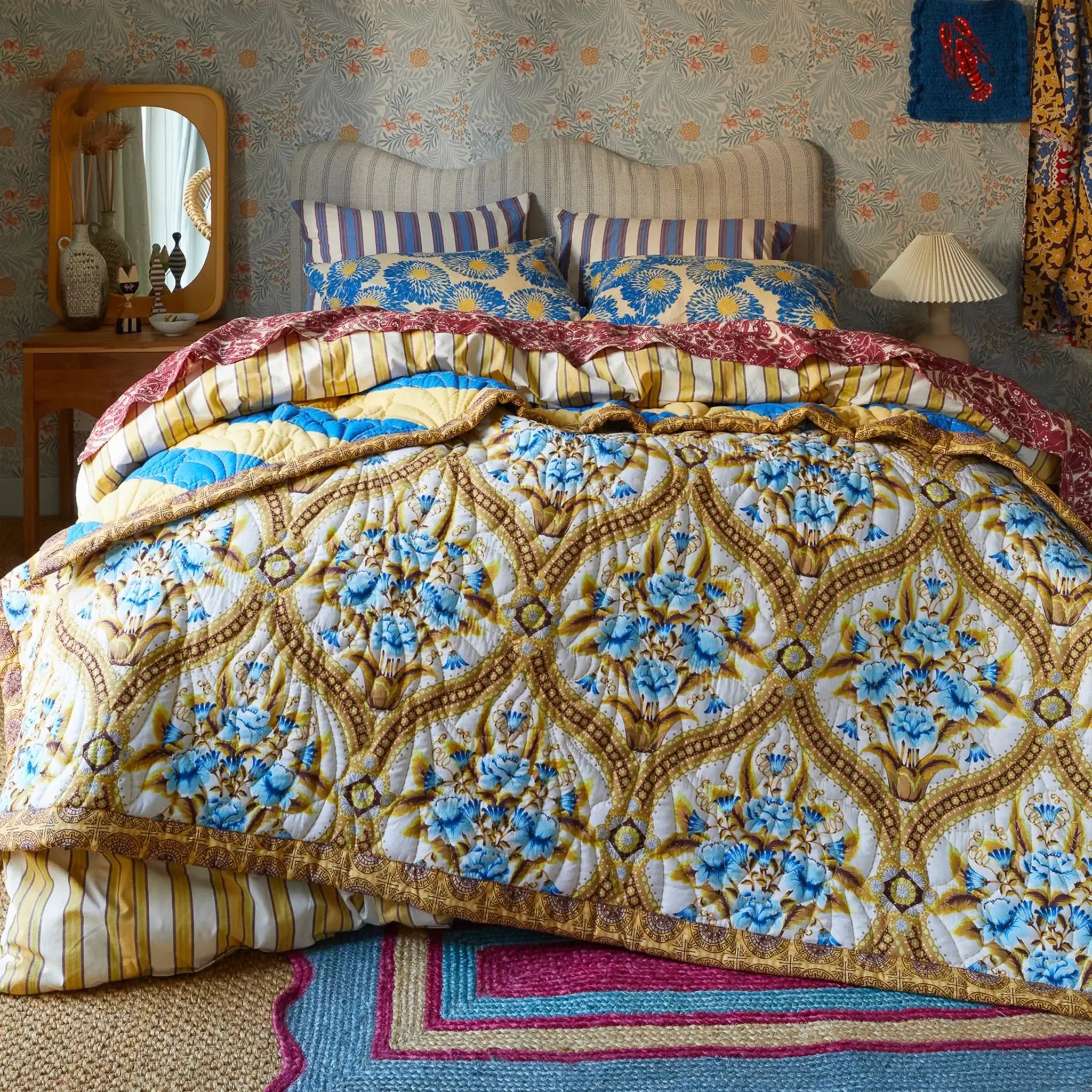Decorative floral quilt on a bed with matching pillows in a bedroom setting.