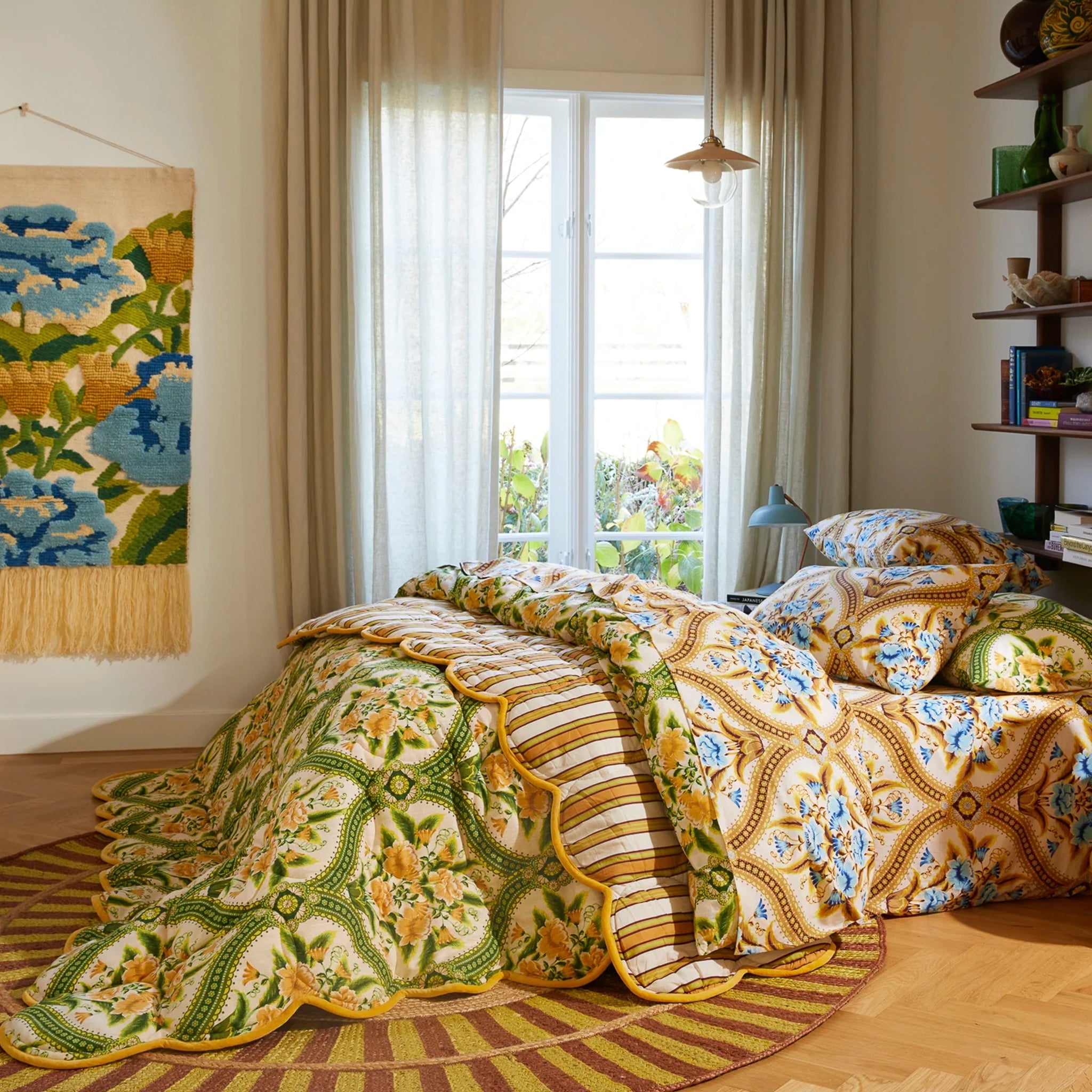 Bedroom with floral-patterned bedding and large windows.