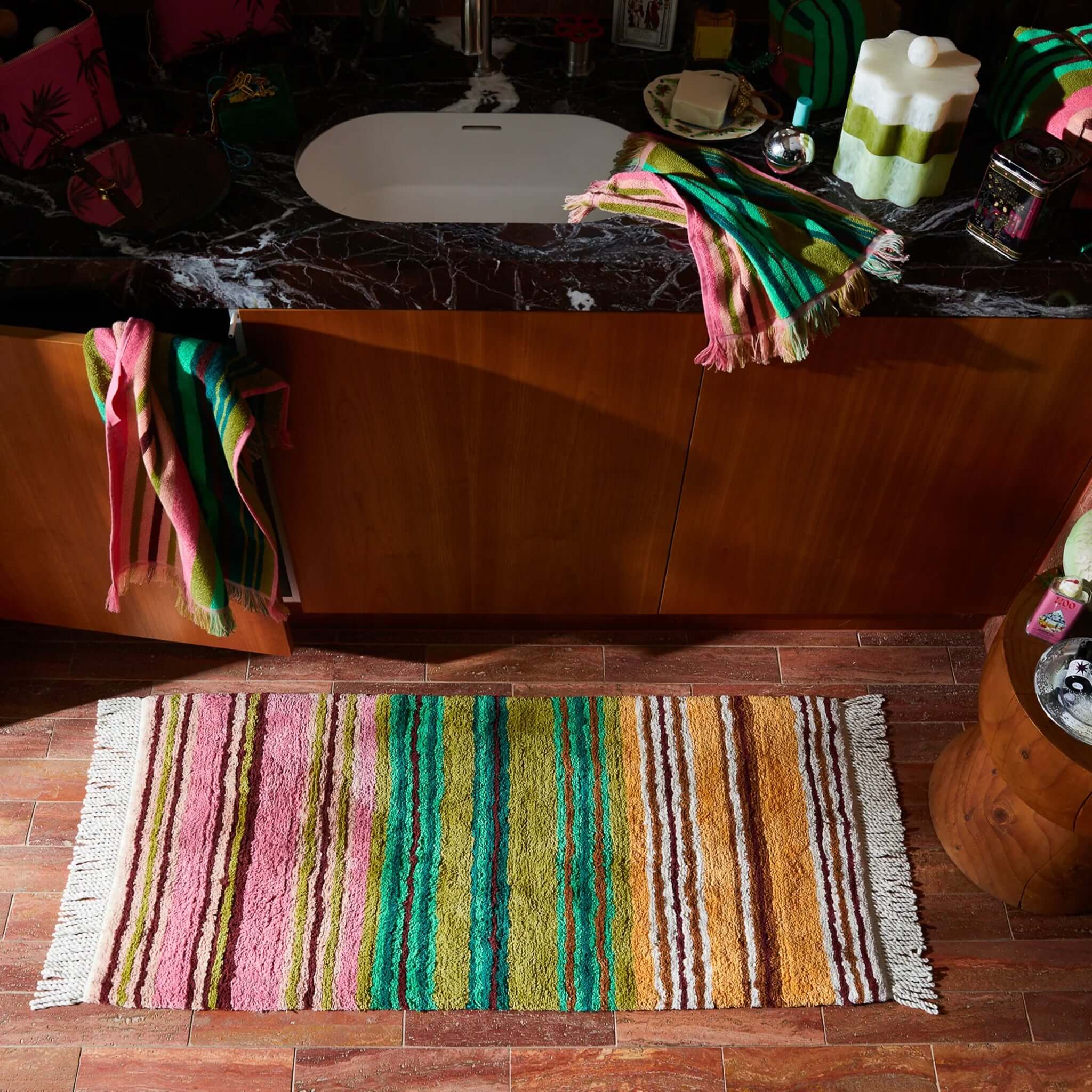 Sage x Clare Nicolette Bath Runner with vibrant multicolour stripes in a stylish bathroom setting.