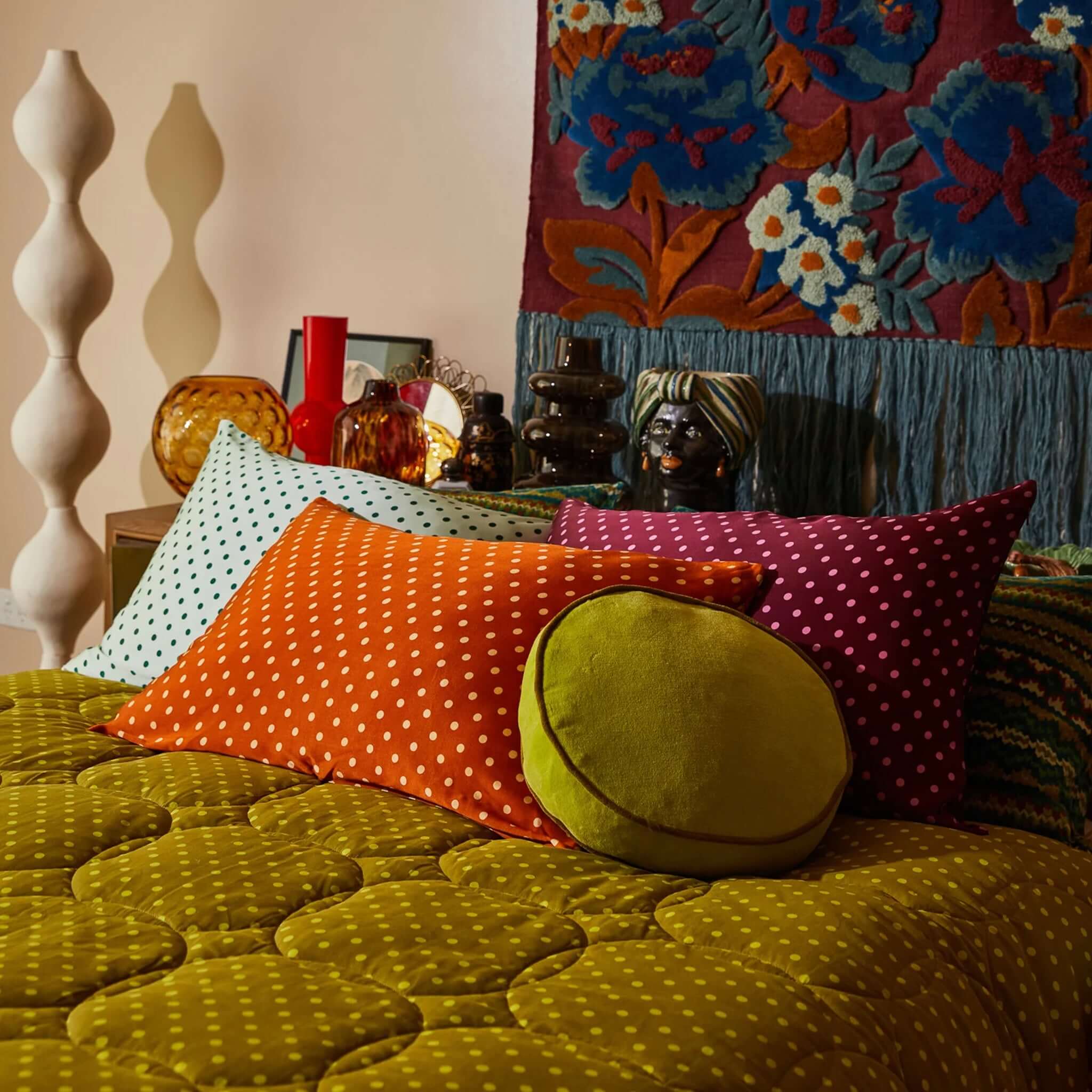 A copper-colored silk pillowcase with a polka dot pattern on a bed.