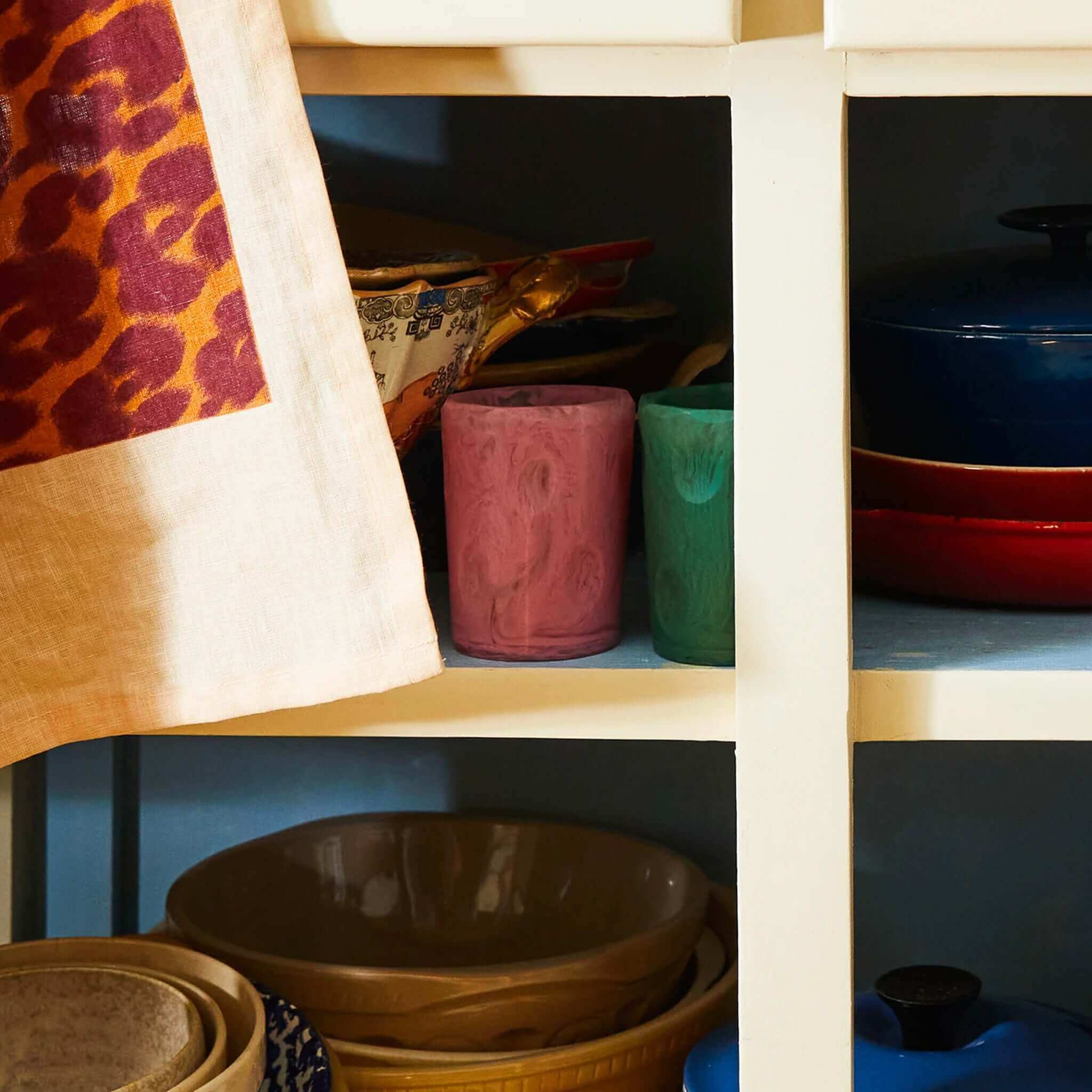 Resin drinking vessels with a cylindrical shape and smooth surface on a shelf.