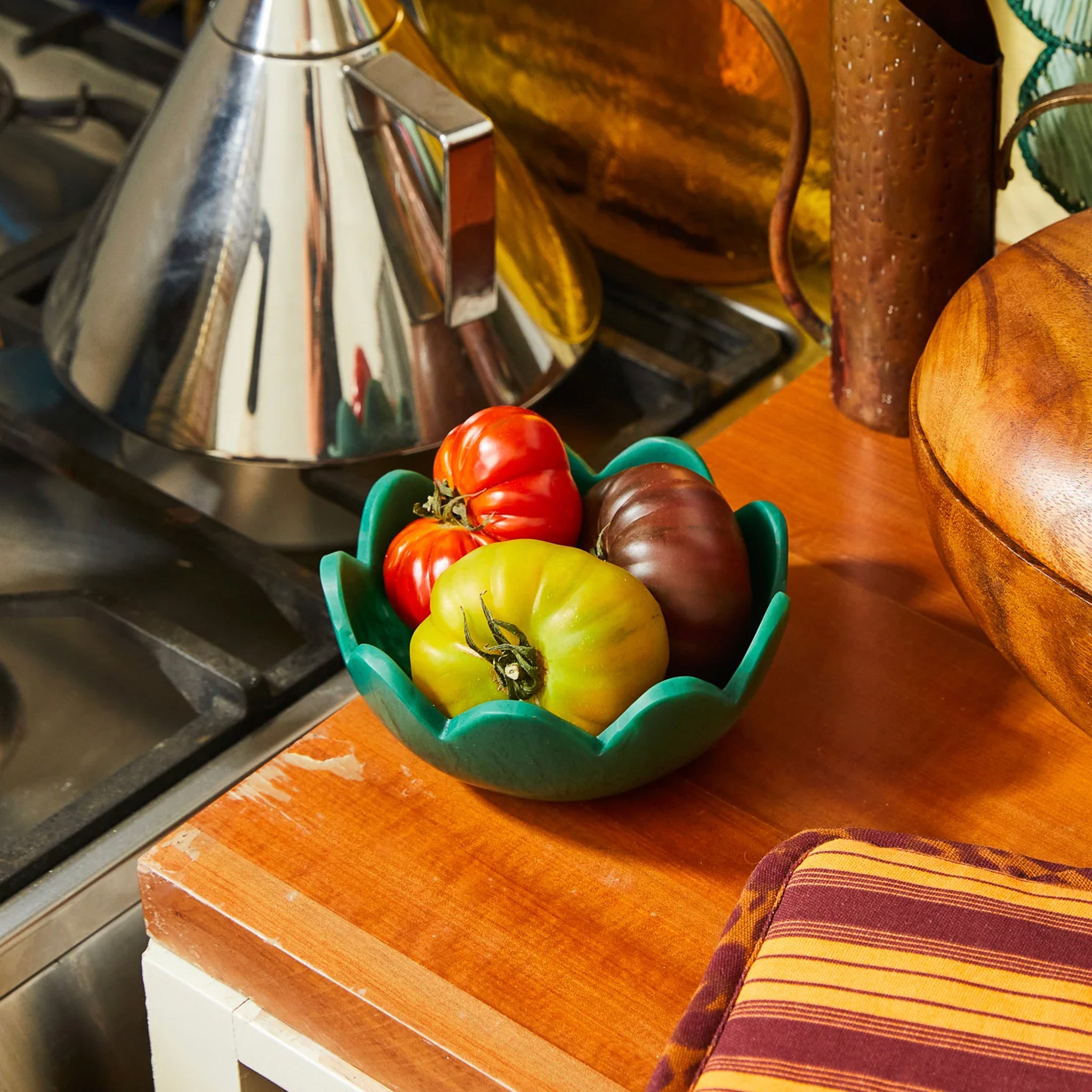 A green, resin petal-shaped bowl with scalloped edges.