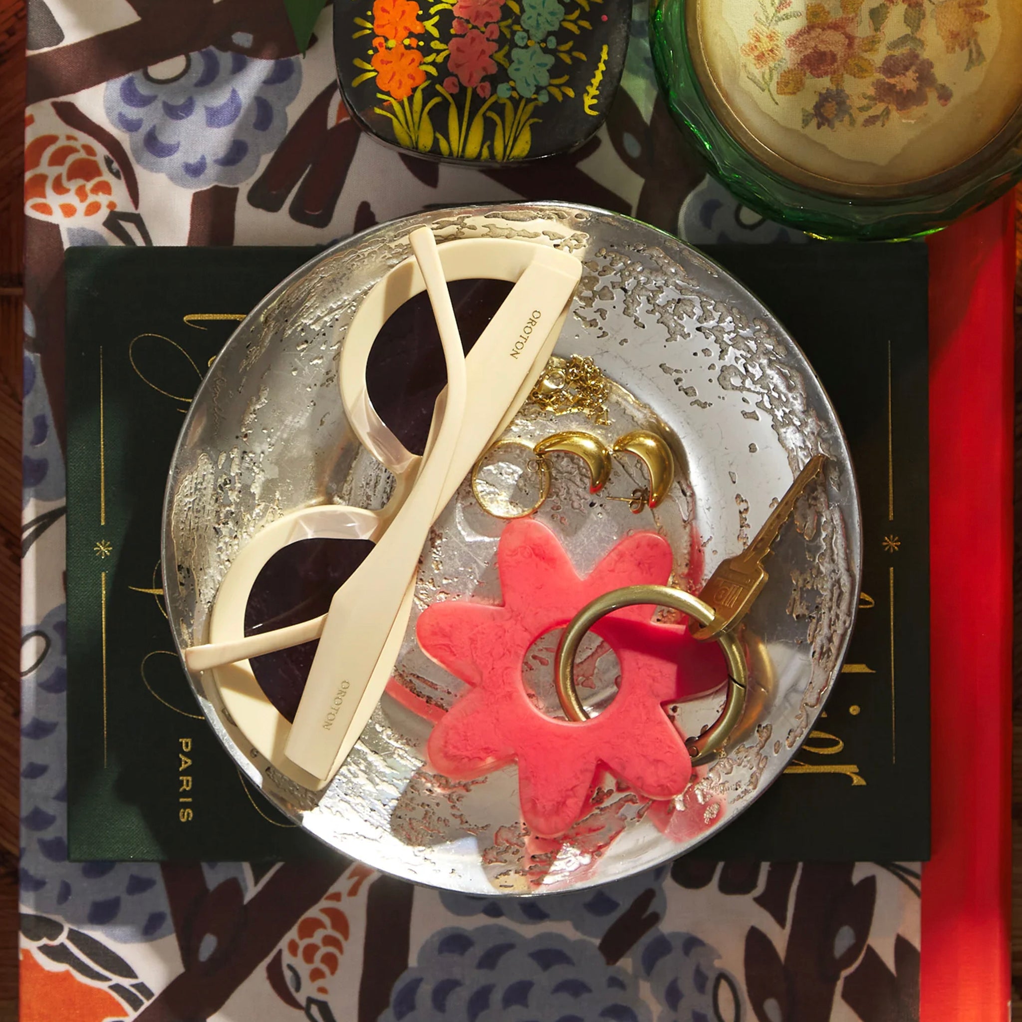 A red flower-shaped keyring made from resin, with a metallic loop for holding keys.