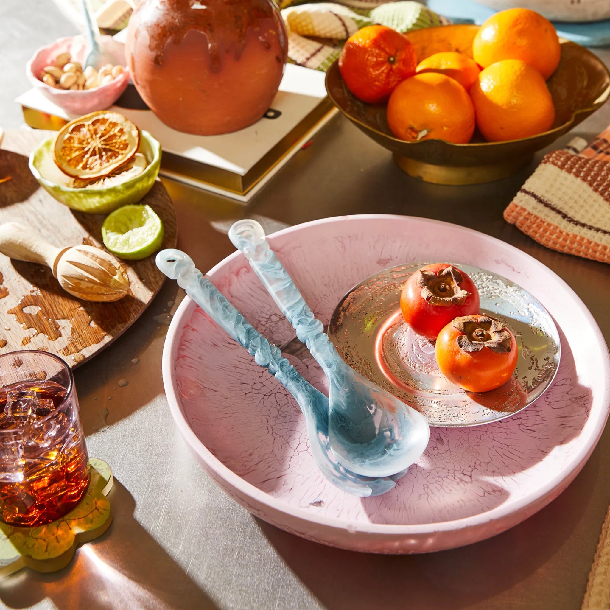 A pink, round, resin serving platter with a smooth surface on a table.