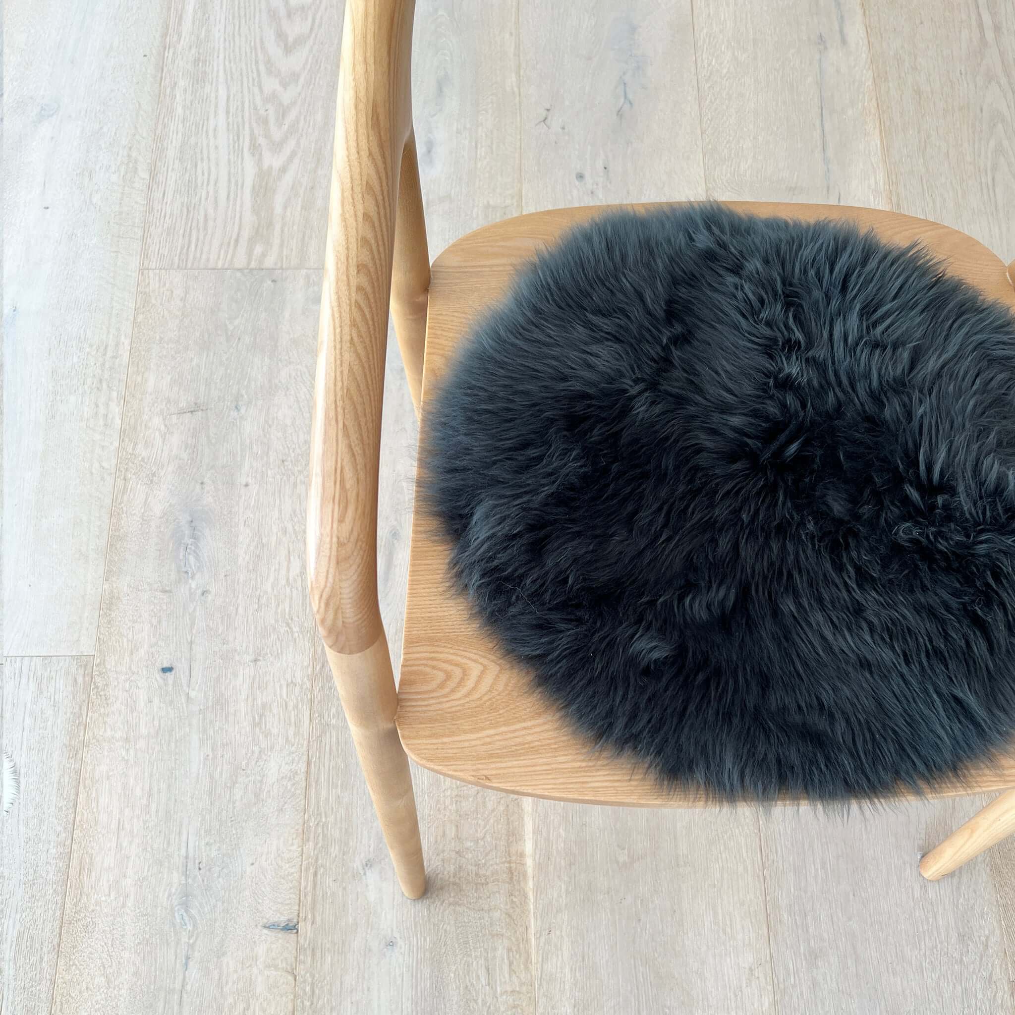 Alt Tag: Long Wool Sheepskin Circle Chair Pad - Steel on wooden chair, round steel-grey long wool sheepskin seat pad