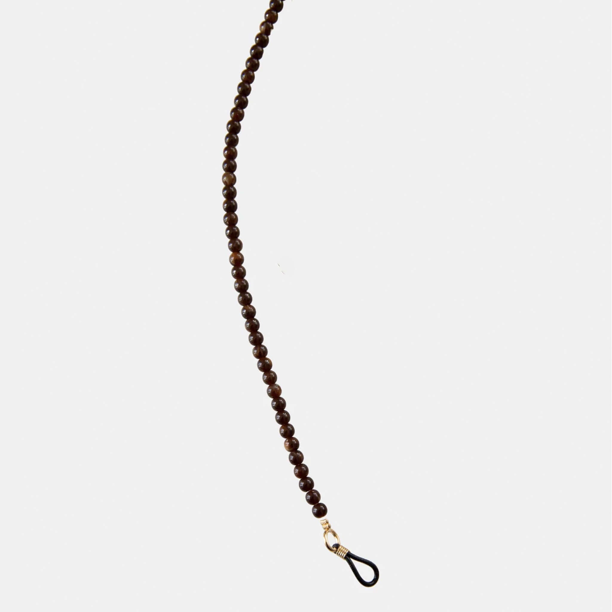 Brown beaded eyeglass holder on a white background
