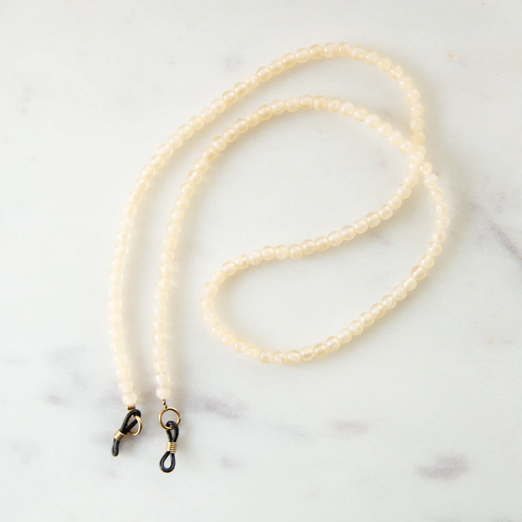 Ivory beaded eyeglass holder on a white background