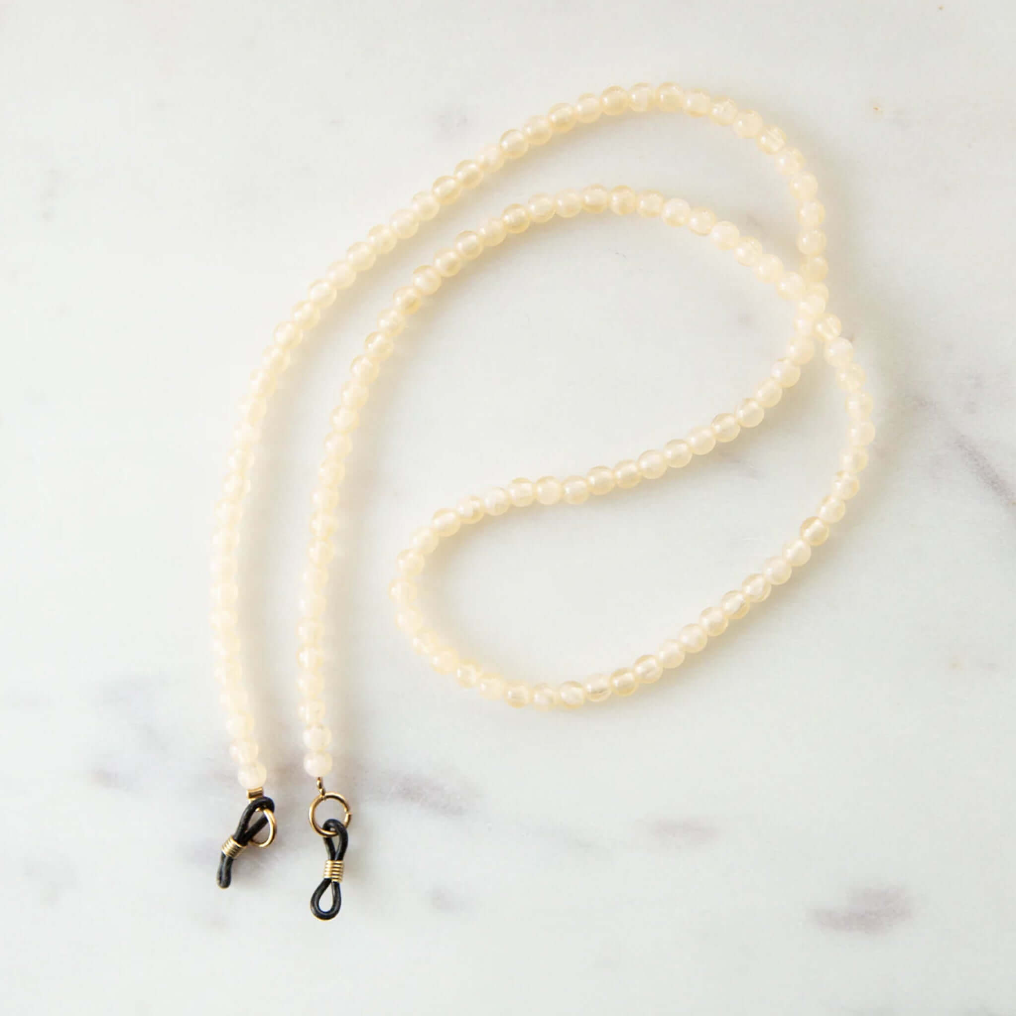 Ivory beaded eyeglass holder on a white background