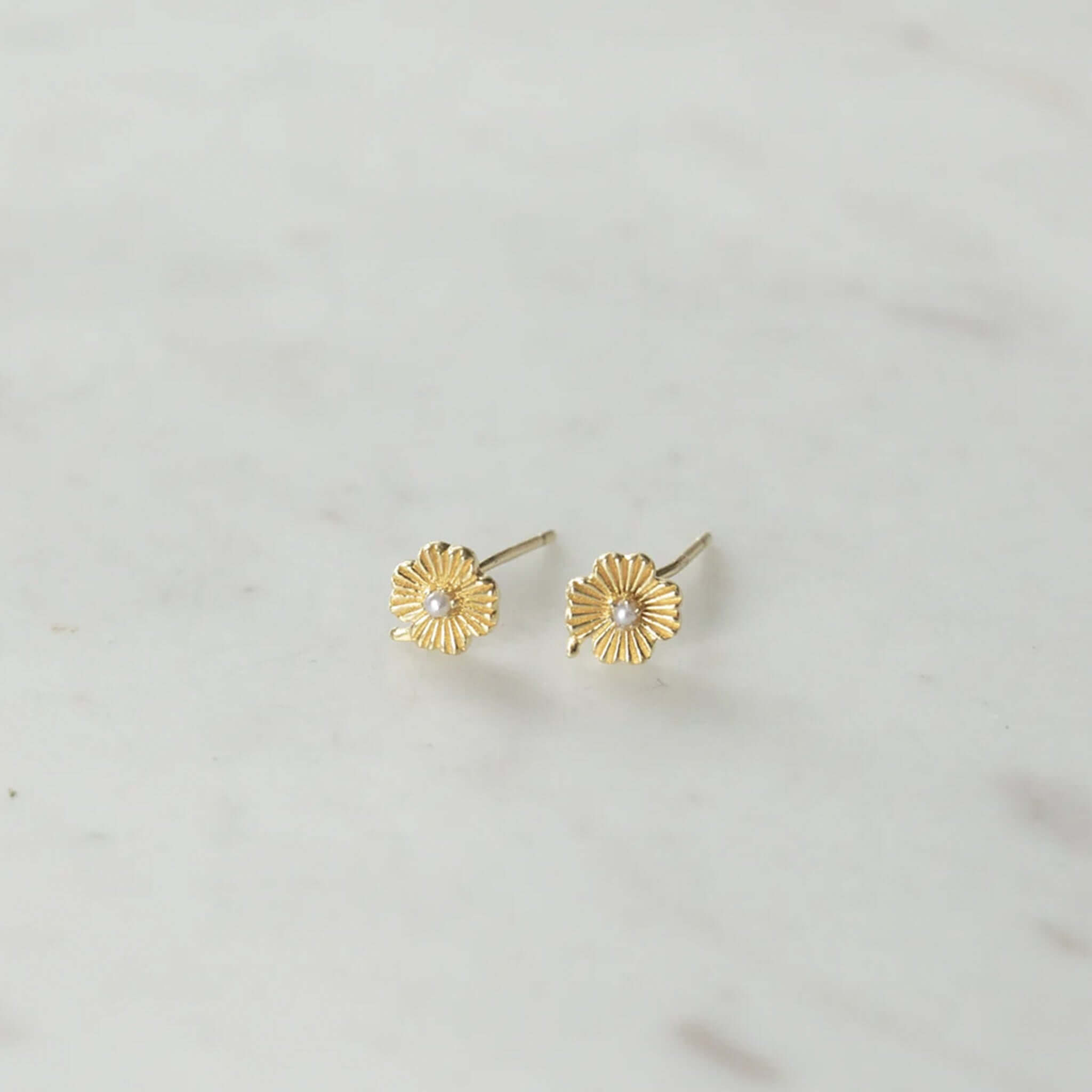 Alt Tag: Sophie Love Lily Stud Earrings gold plated sterling silver lily flower studs with pearl center on marble background