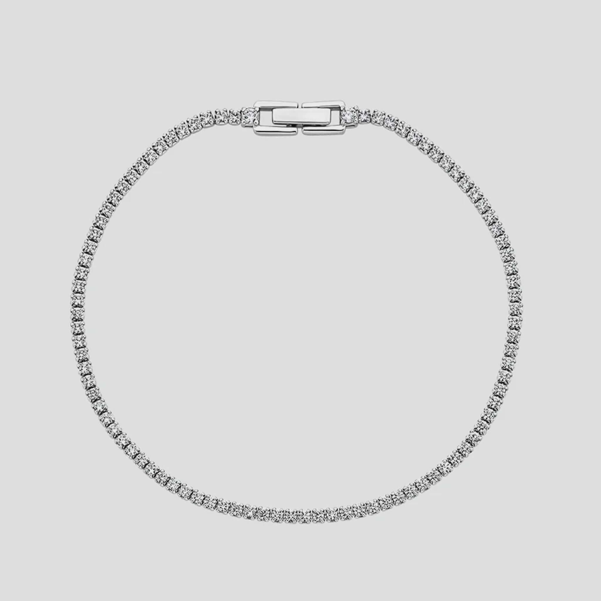 Silver bracelet with clear stones on a light gray background