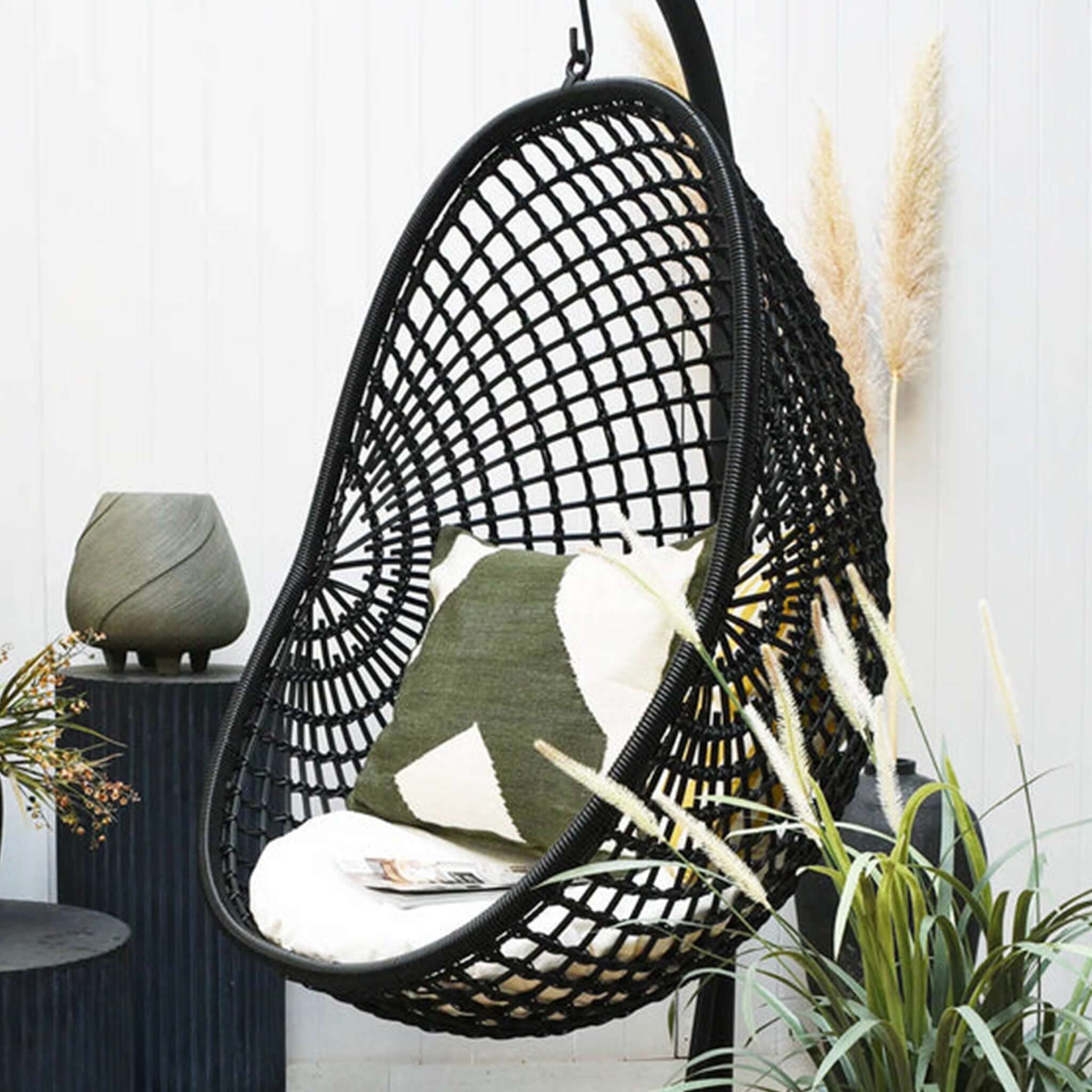 Alt Tag: Synthetic Rattan Outdoor Pod Chair - Check Black hanging pod chair with black woven rattan, cushion and outdoor decor
