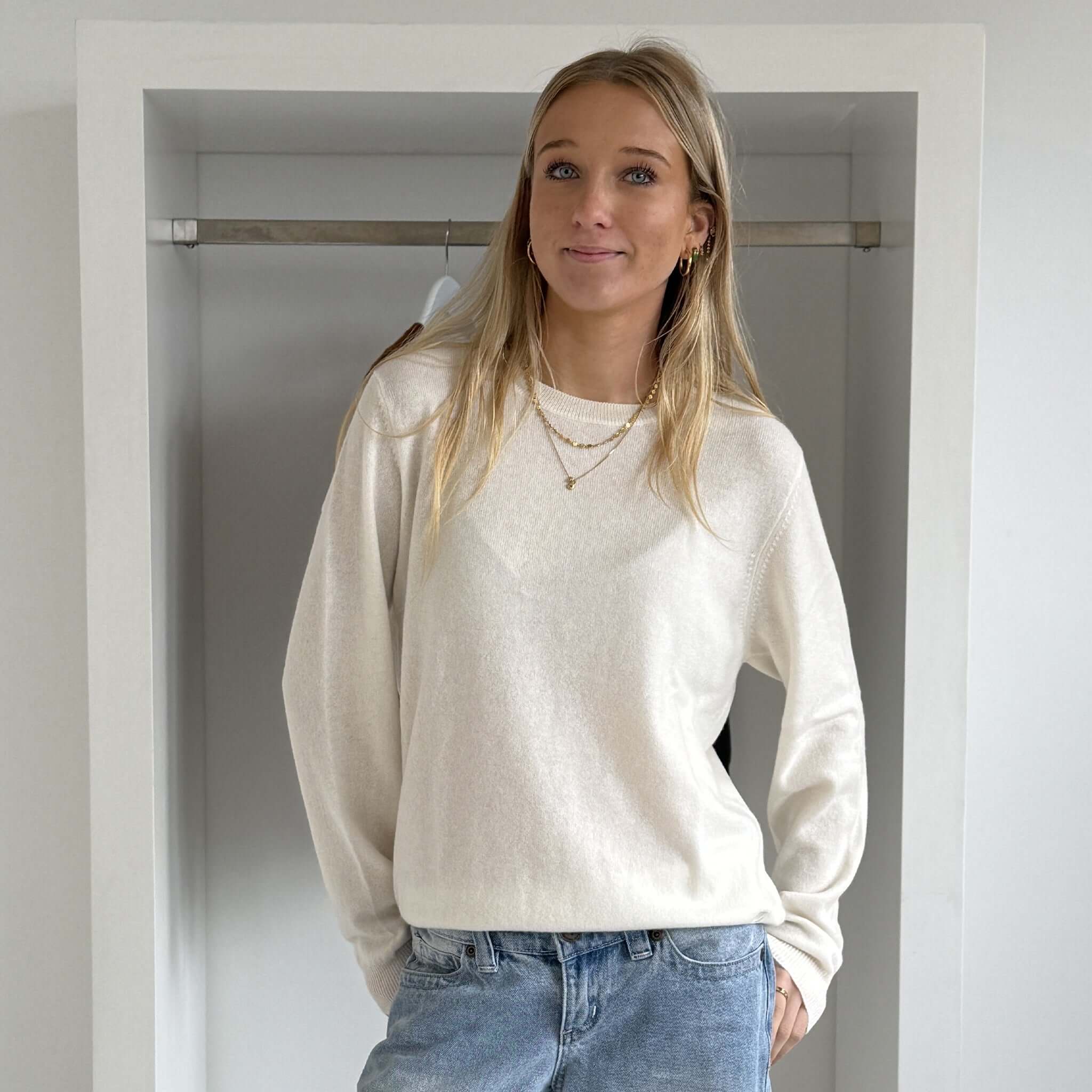 Model wearing The Uniform Cashmere Crew Neck Sweater - Milk, showcasing its relaxed fit and elegant design.