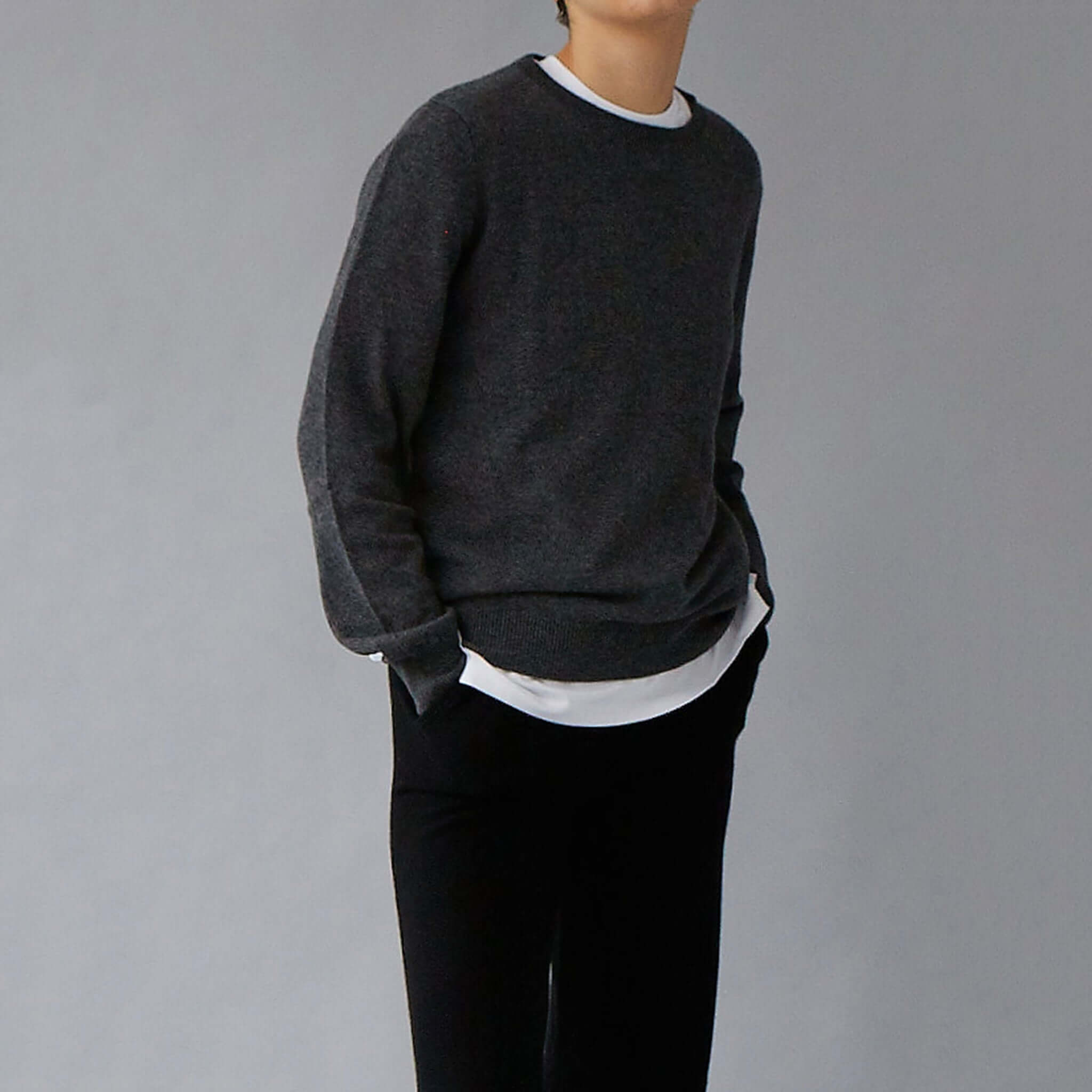 Alt Tag: The Uniform Cashmere Crew Neck Sweater - Charcoal long-sleeve crewneck in relaxed fit with ribbed trim, styled on model
