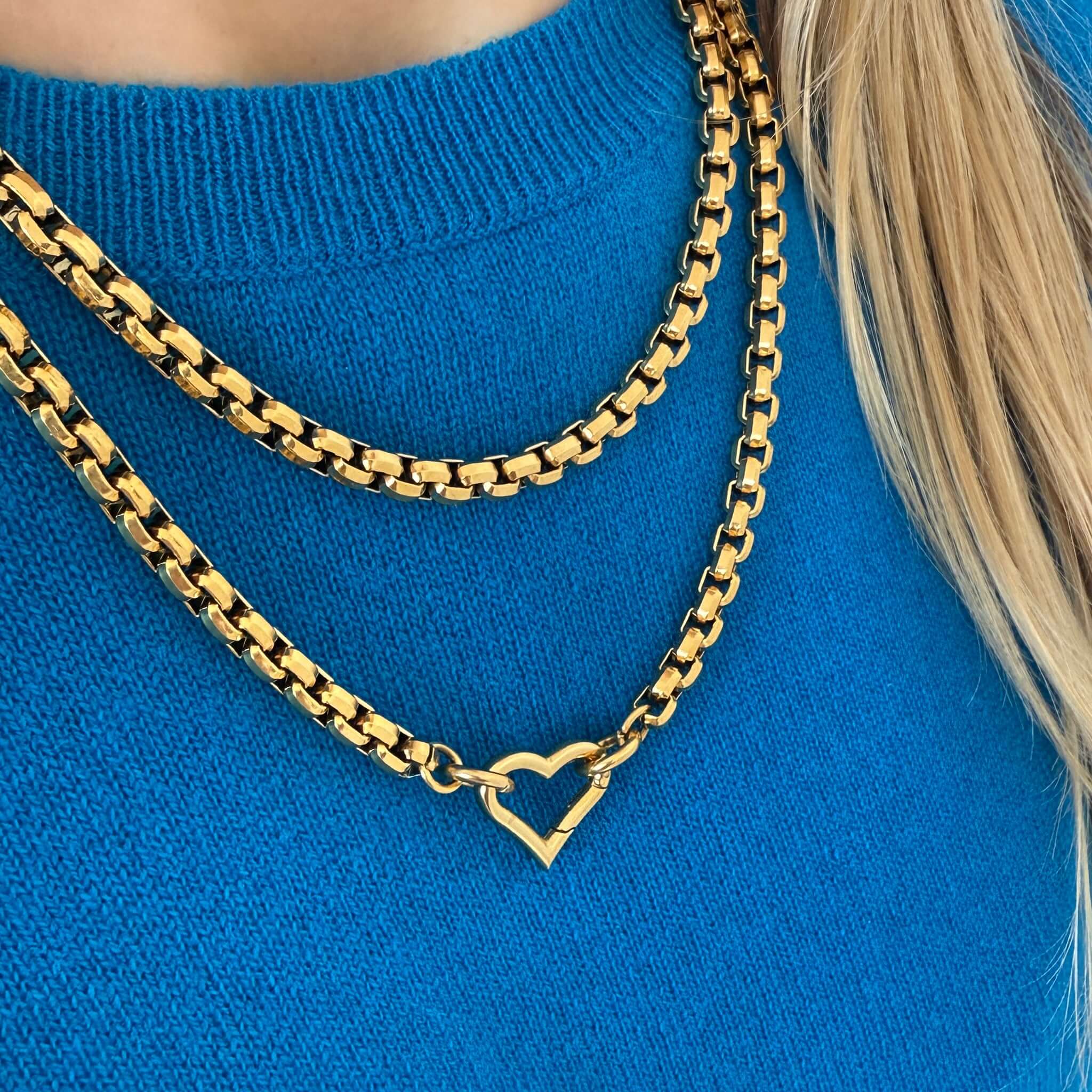 The Uniform Cashmere Crew Neck Sweater - Sapphire worn with layered gold chains featuring a heart pendant.
