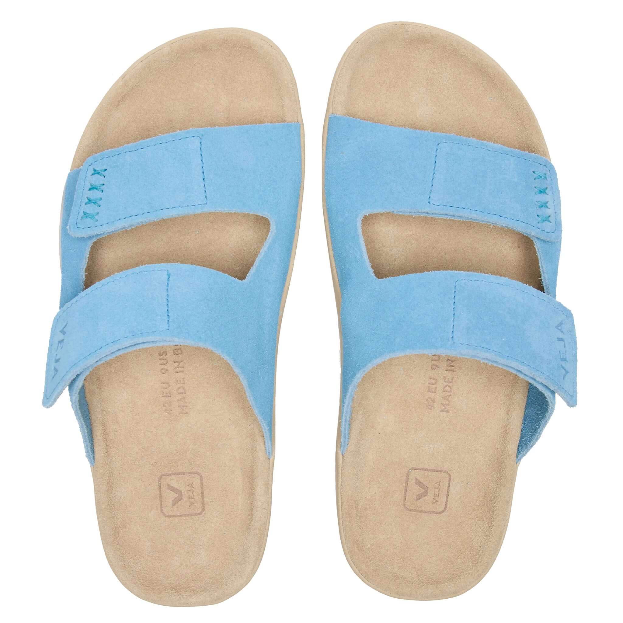 Pair of blue sandals with beige soles on a white background