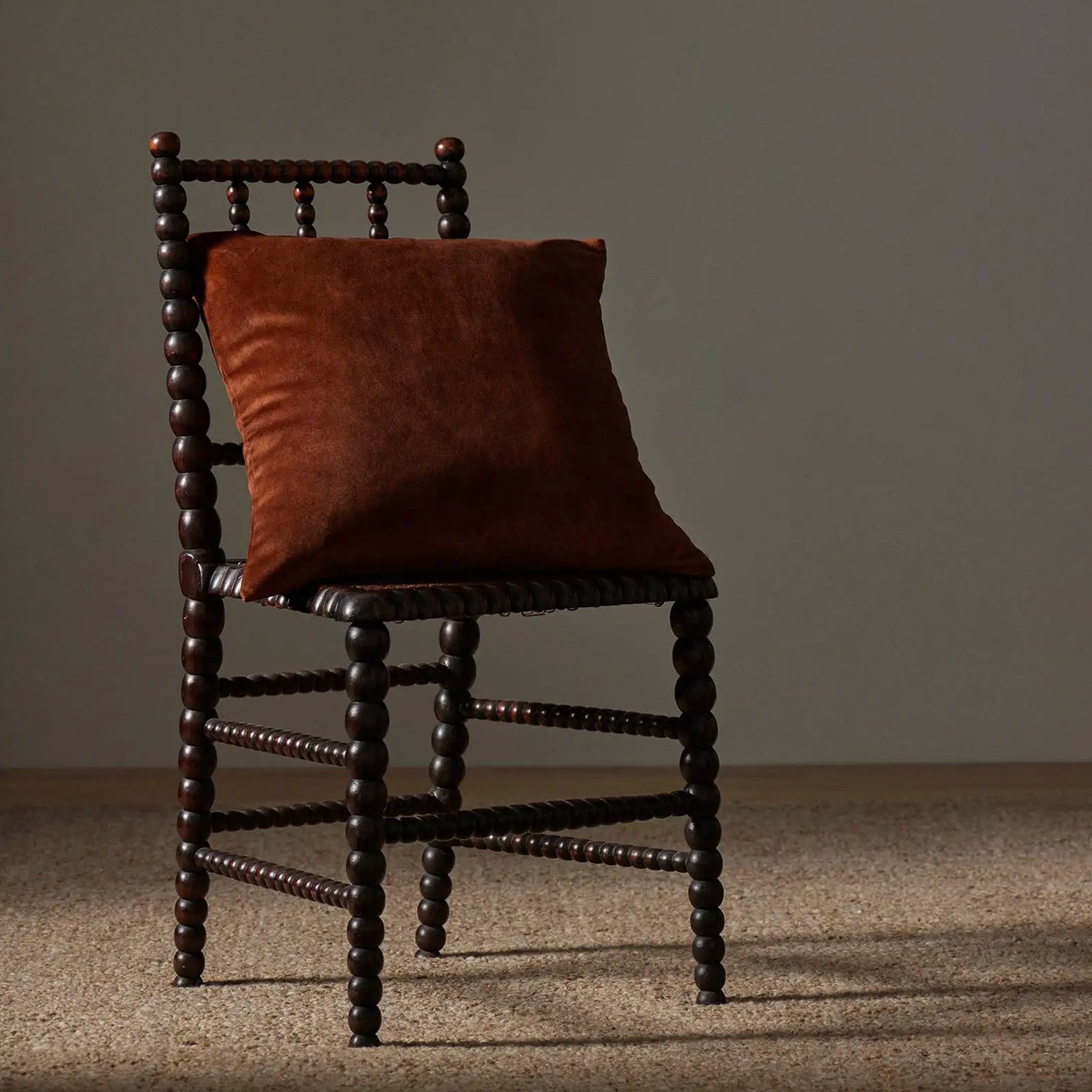 Brown velvet cushion on a chair.
