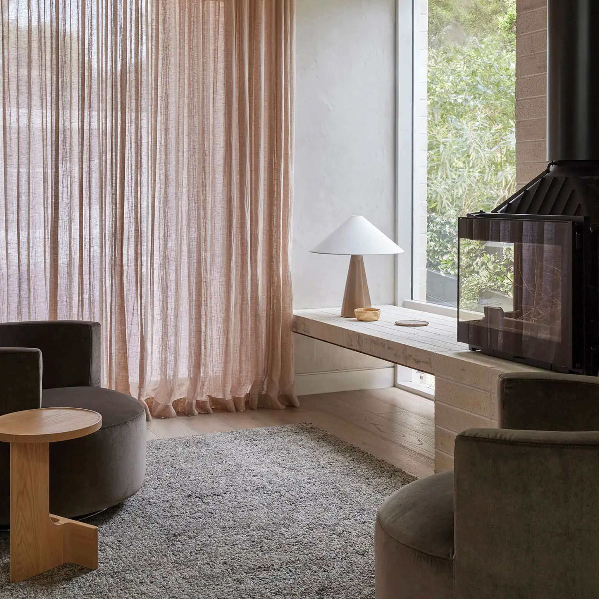 Modern living room with a fireplace, curtains, and furniture.