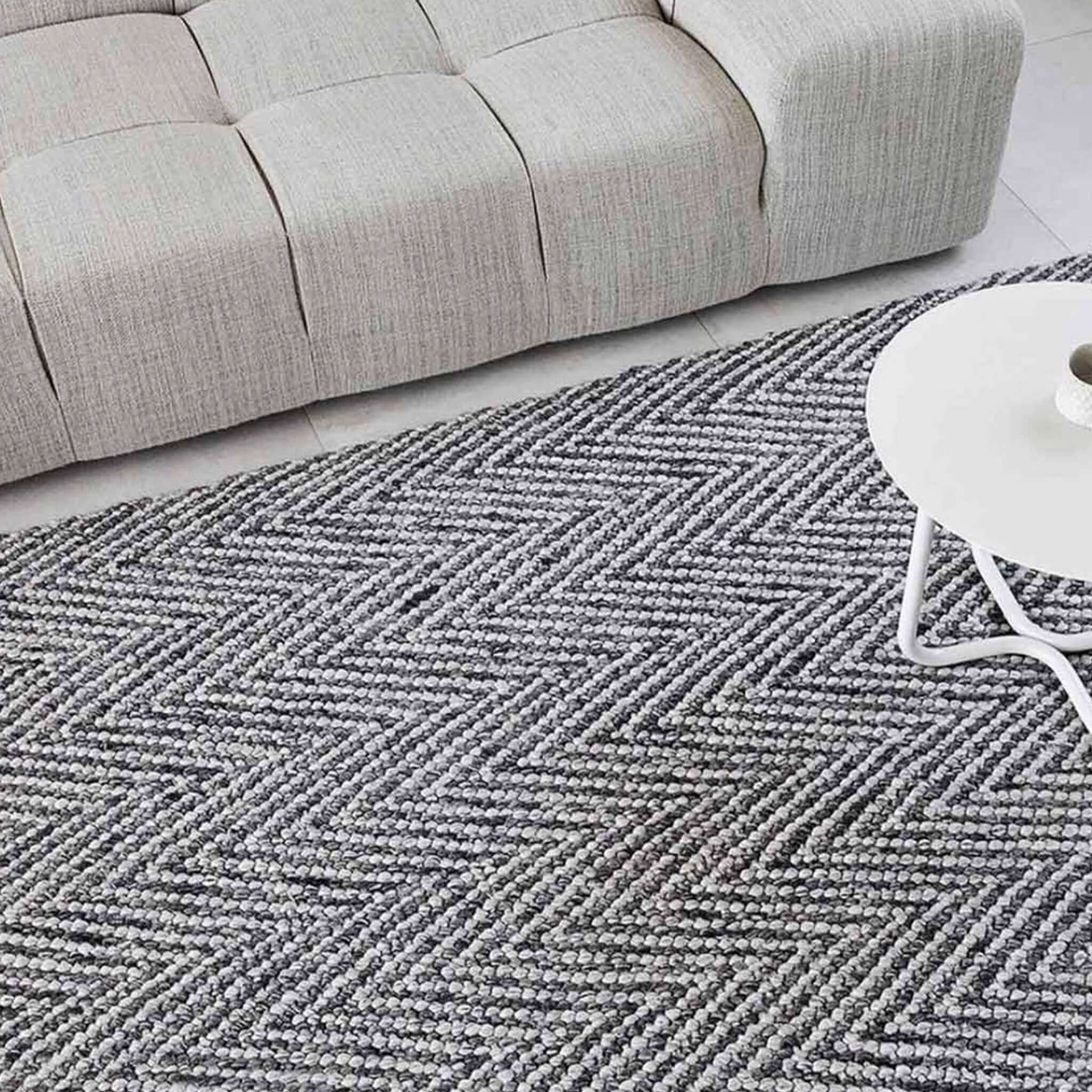 Gray and white chevron patterned rug in a lounge.