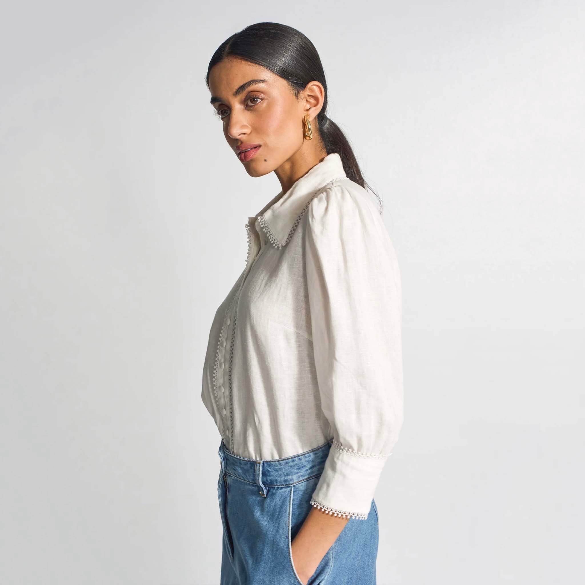 Zoe Kratzmann Serenade Top - Porcelain, featuring delicate lace trim and self-covered buttons, styled with denim.