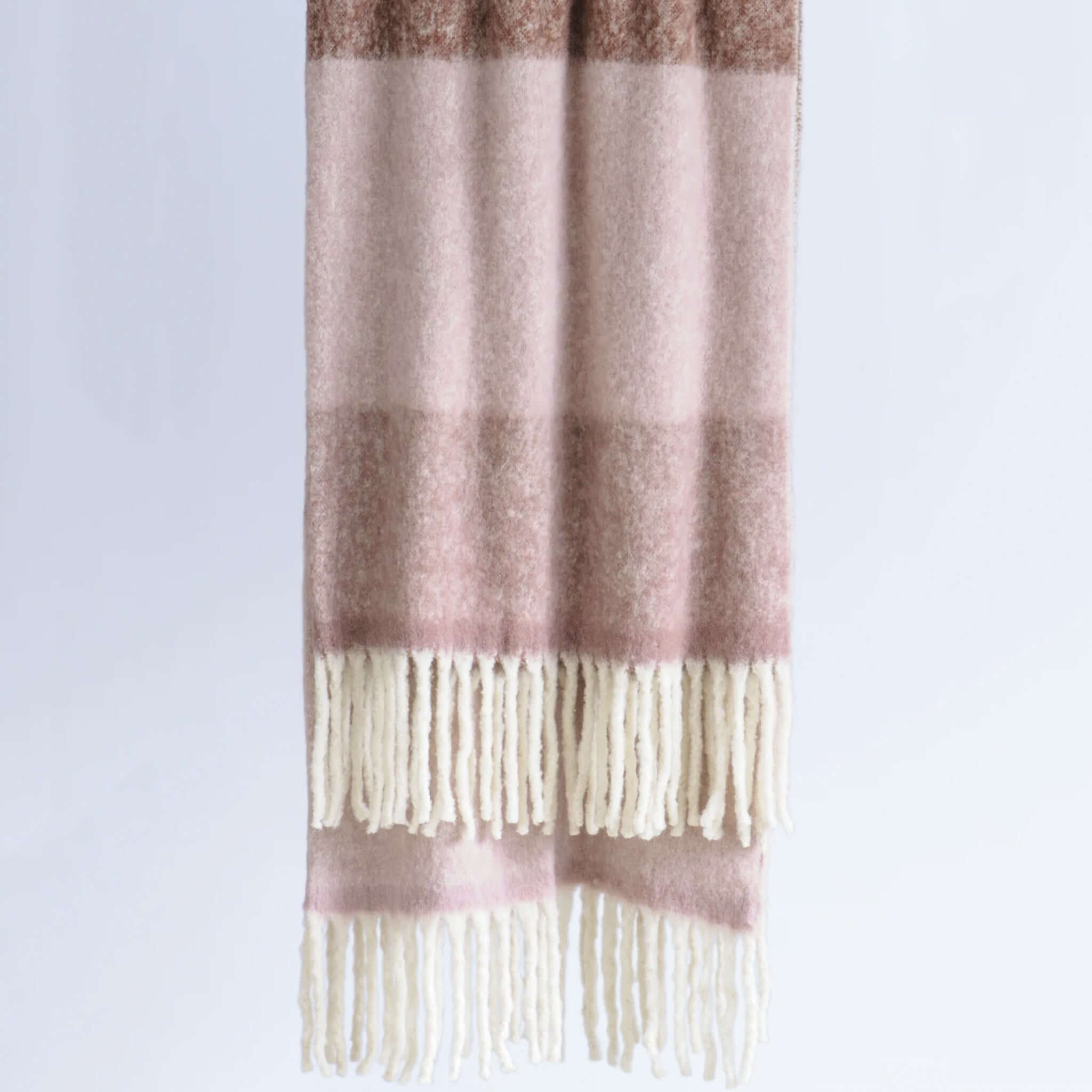 Bianca Lorenne Arundel Throw - Plum Blossom hanging with tassels, perfect for cozying up in any space.