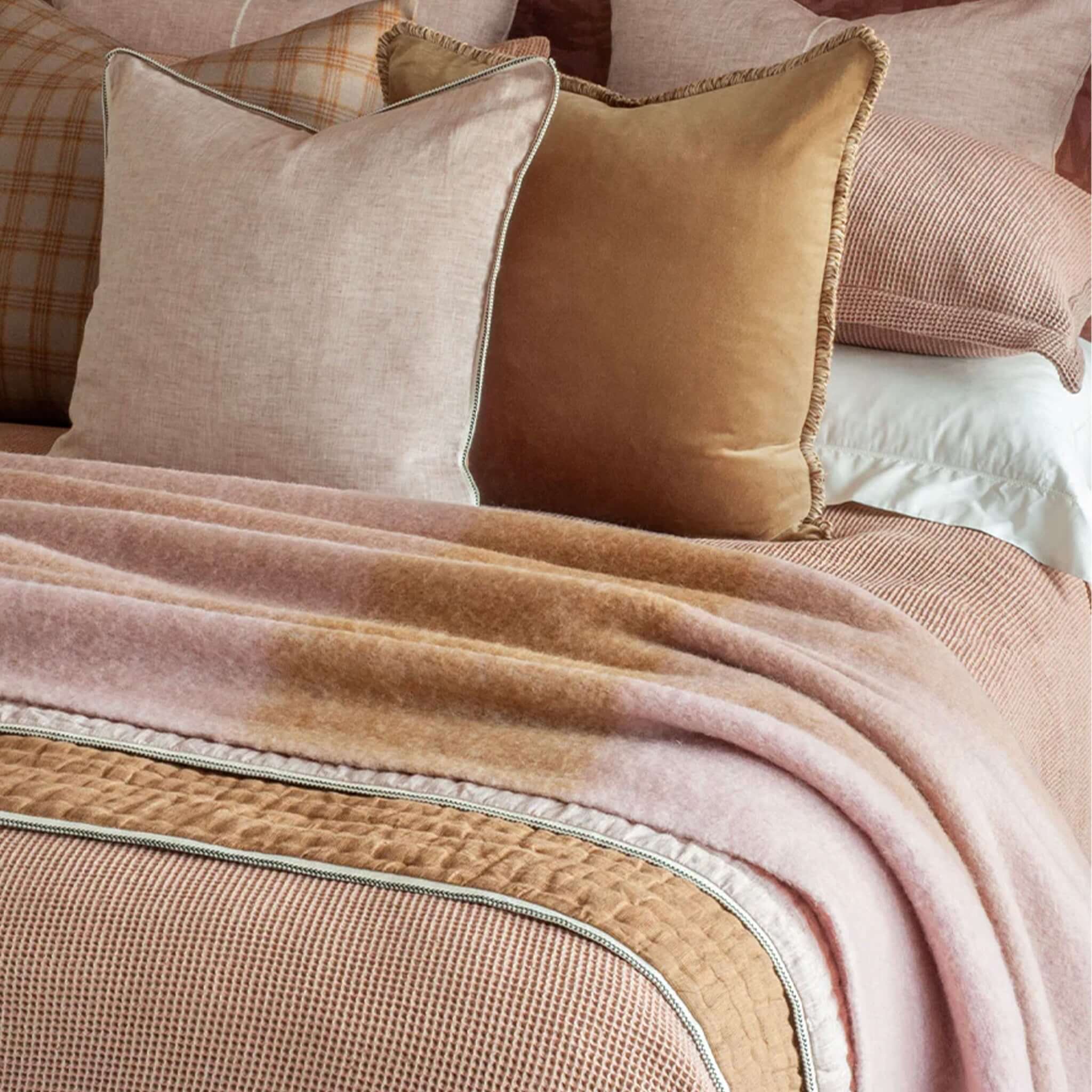 Bianca Lorenne Komichi Throw - Old Rose draped over bedding with decorative pillows.