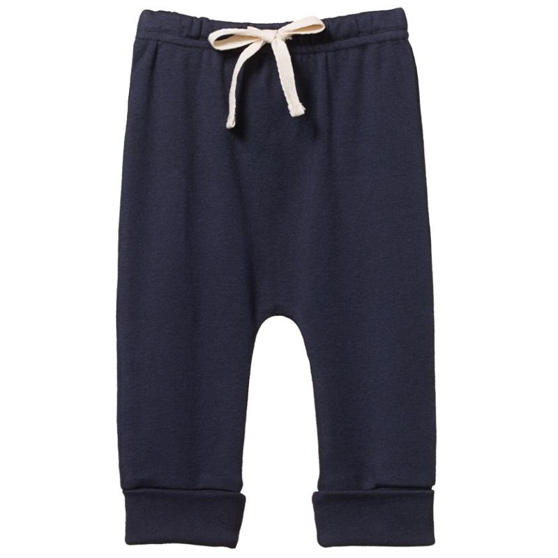 Navy blue organic cotton drawstring pants for babies with a cuffed tapered leg and elastic waist.