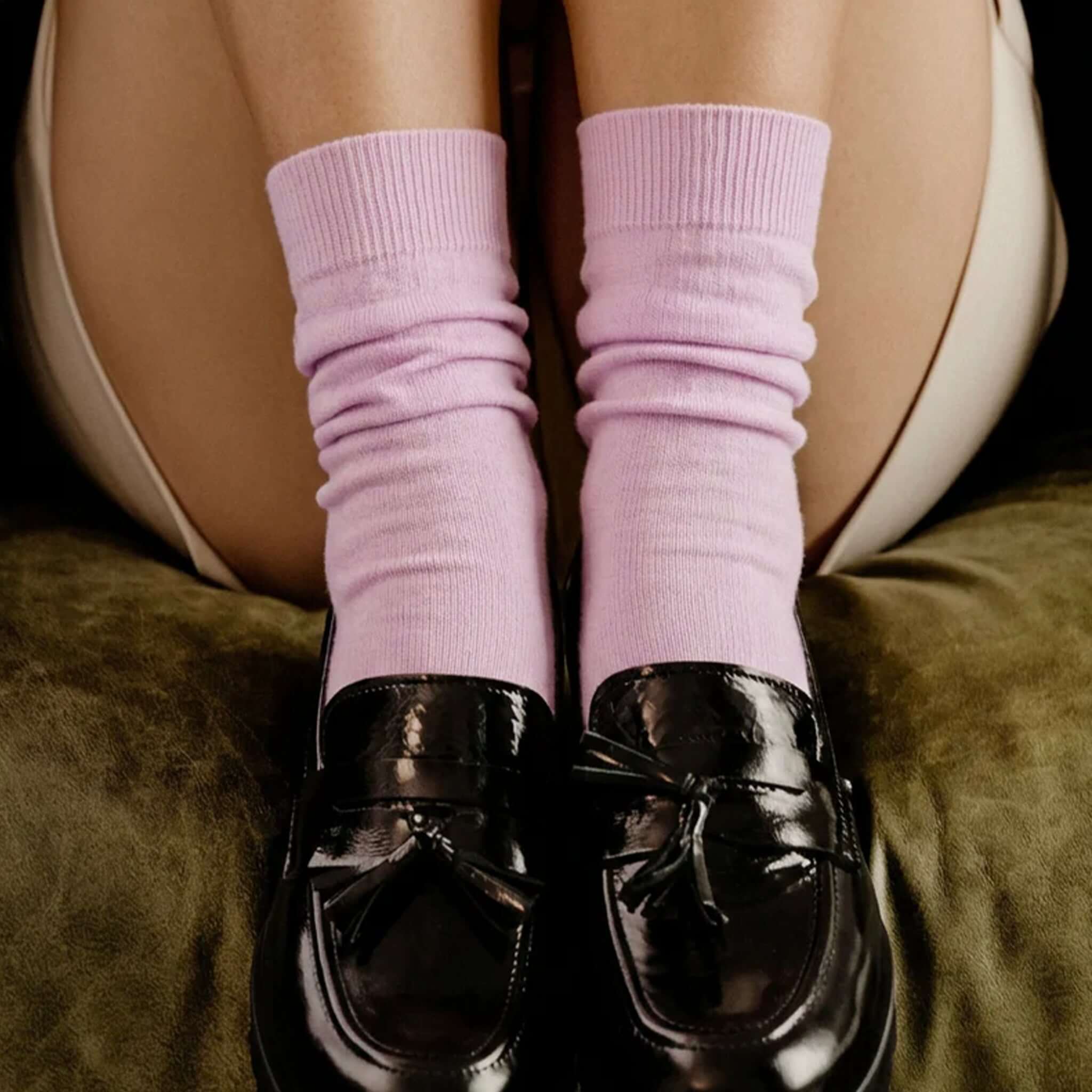 Nooan Hamilton Possum Merino Hamilton Socks - Festive Bloom worn with black loafers on a green sofa.