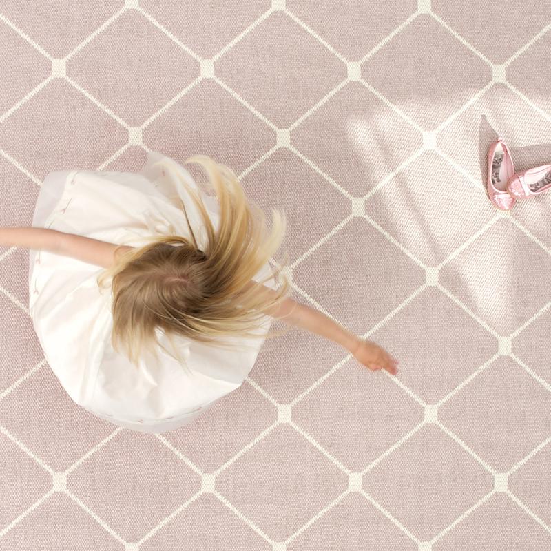 Alt Tag: Pappelina Sweden Rex Reversible Mat - Pale Rose & Vanilla tile-inspired reversible rug, pale rose and vanilla pattern with child spinning