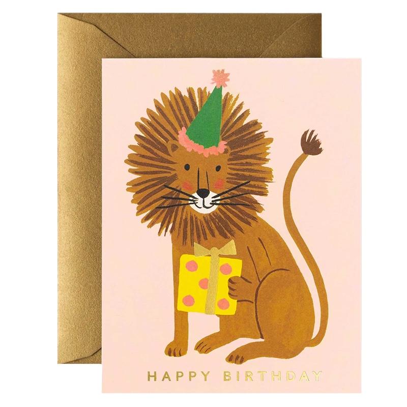A greeting card featuring an illustration of a lion wearing a party hat and holding a gift box with the text 'HAPPY BIRTHDAY' on the front.