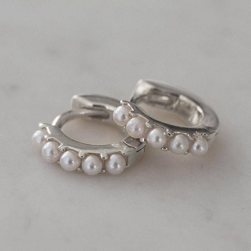 Alt Tag: Sophie Mini Pearl Huggie Earrings in sterling silver with mini faux pearls, 11mm huggie hoops close-up