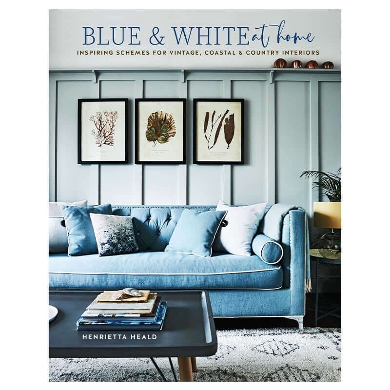 Alt Tag: Blue & White at Home: Inspiring Schemes for Vintage, Coastal & Country Interiors book cover with blue sofa and coastal wall art