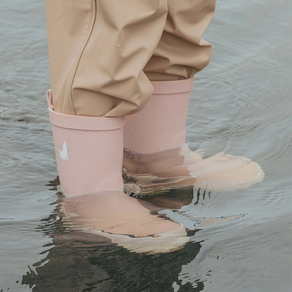 Alt Tag: Crywolf Rain Boots - Dusty Pink kids waterproof natural rubber gumboots with high-grip tread, cotton lining, splashing in puddle