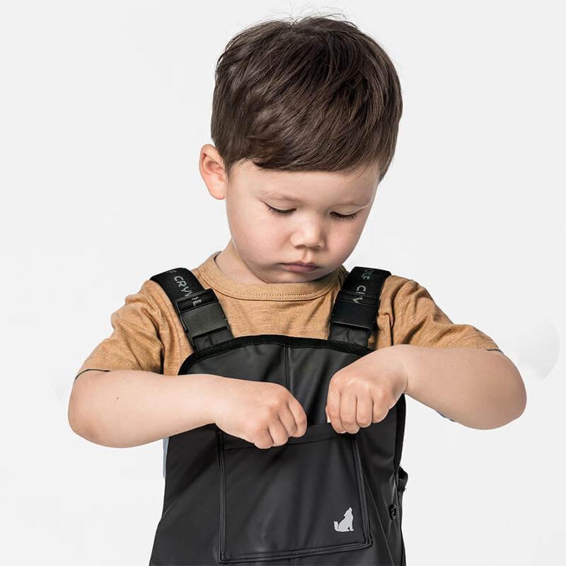 Alt Tag: Crywolf Rain Overalls - Black on child, fully waterproof adjustable kids rain overalls for outdoor play and rainy day adventures