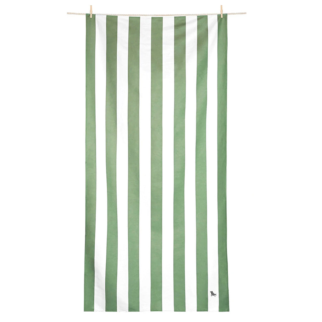 A green and white striped beach towel with an elastic hook at the top, hanging on a wooden rod.