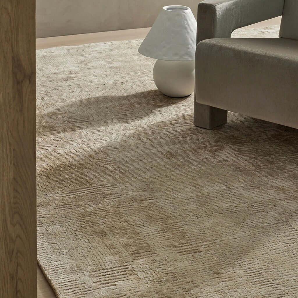 Fawn rug and chair on a wooden floor.