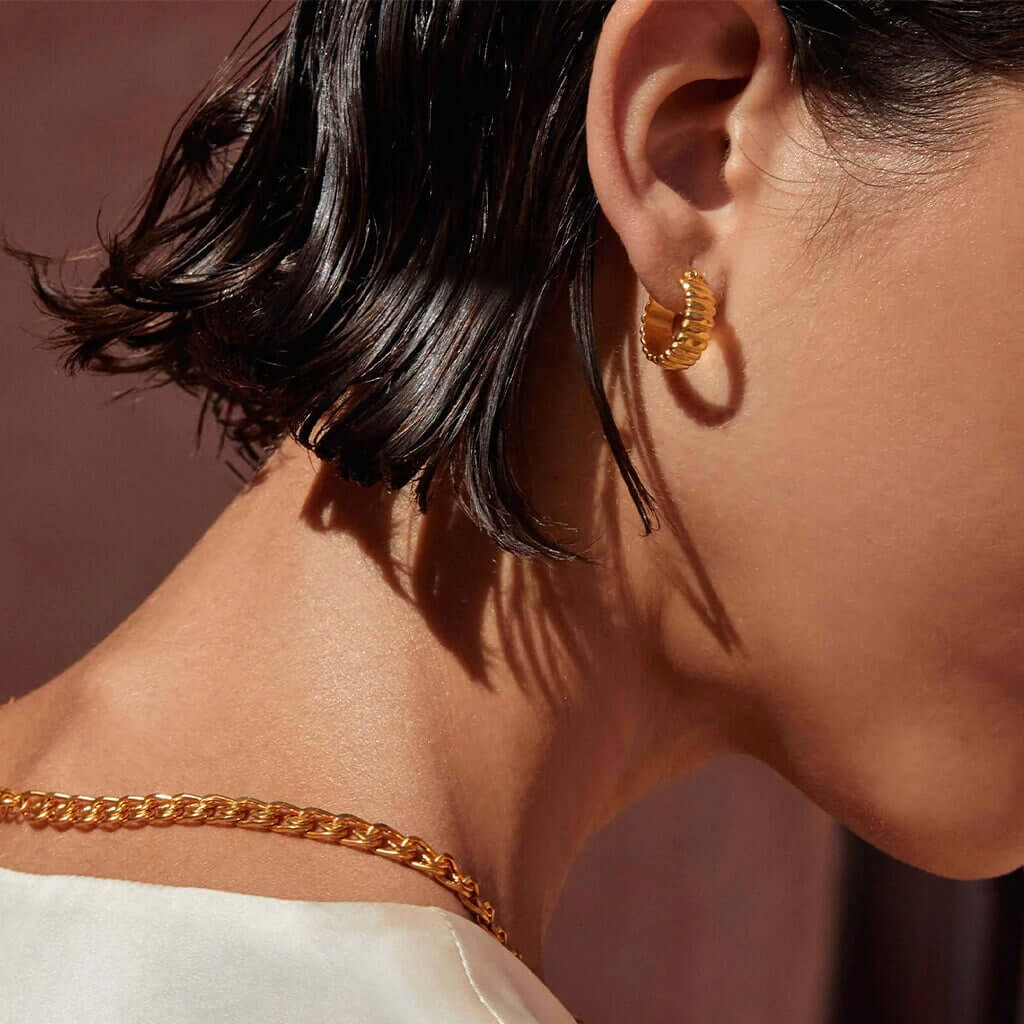 Alt Tag: Kirstin Ash Sun Lines Collection Cisco Hoop Earrings 18K gold plated vermeil textured hoop earrings worn on ear, light-refracting design