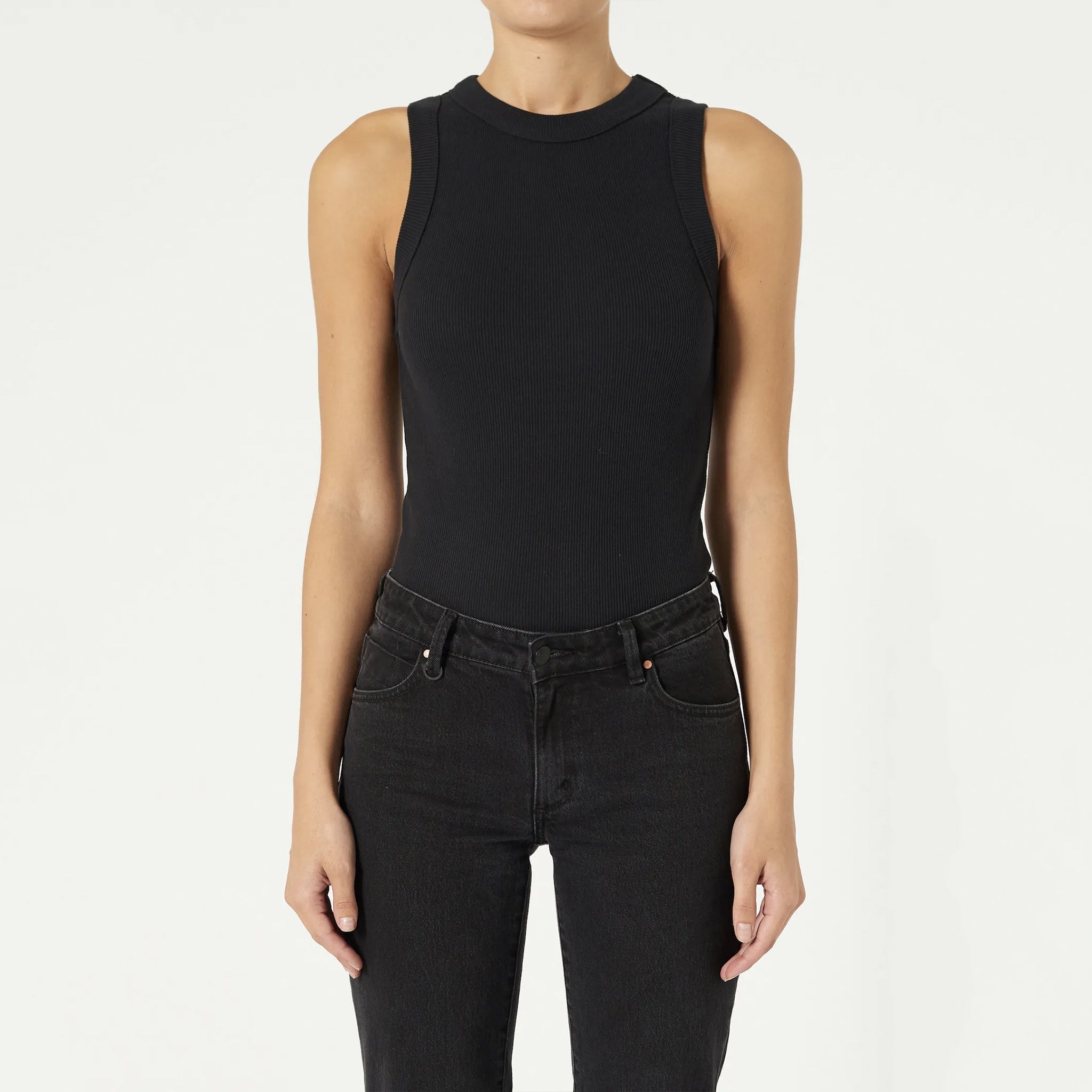 A female model wearing a black singlet and jeans. The singlet is sleeveless with a slim fit and wide rib binding at the hem.