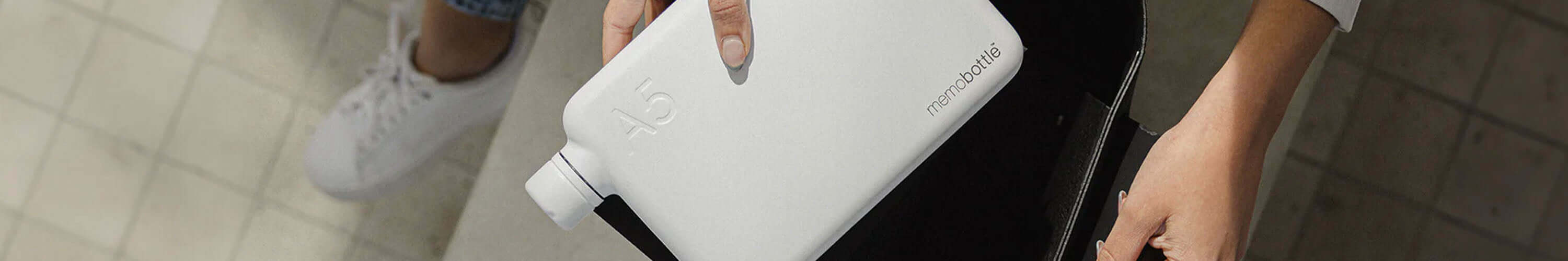 Memobottle slim flat reusable water bottle in white, space-saving design fits easily in bag for commuting and everyday hydration