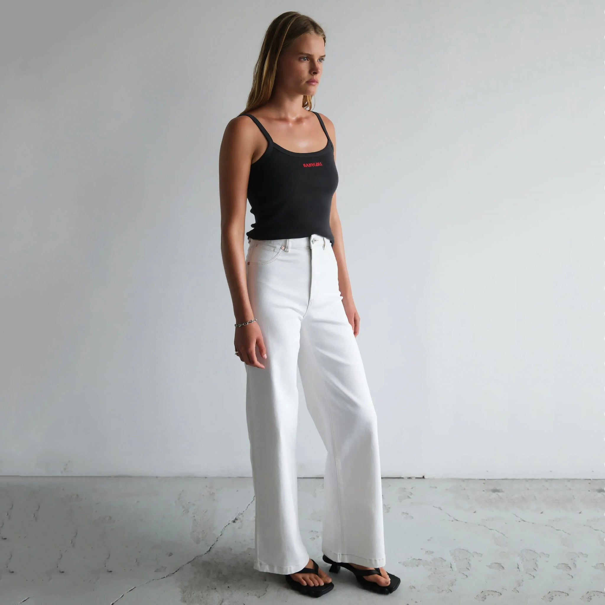 Woman wearing a pair of Abrand 94 High & Wide Jeans in Western White.